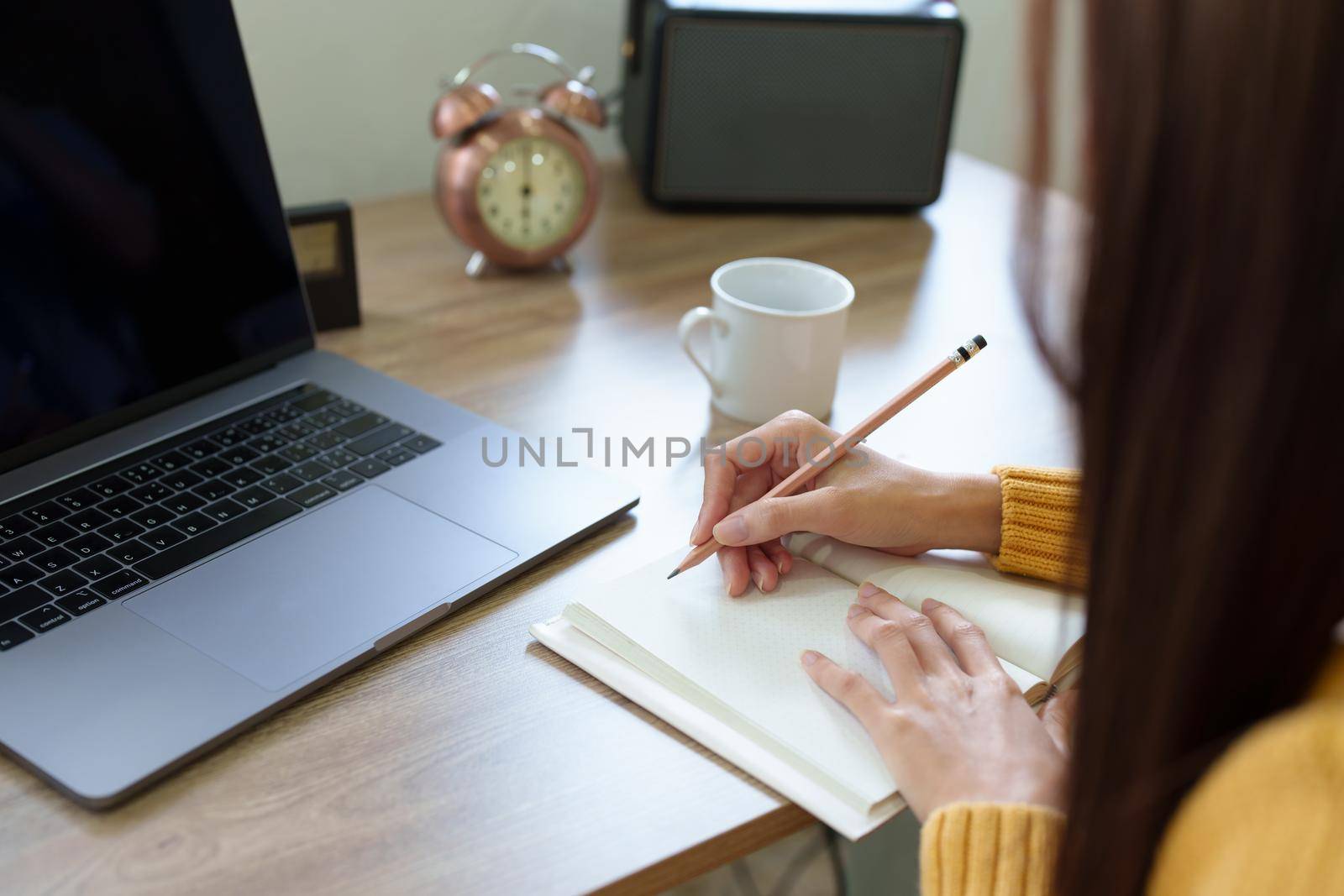 A woman using a pencil to write down memories in a notebook by Manastrong