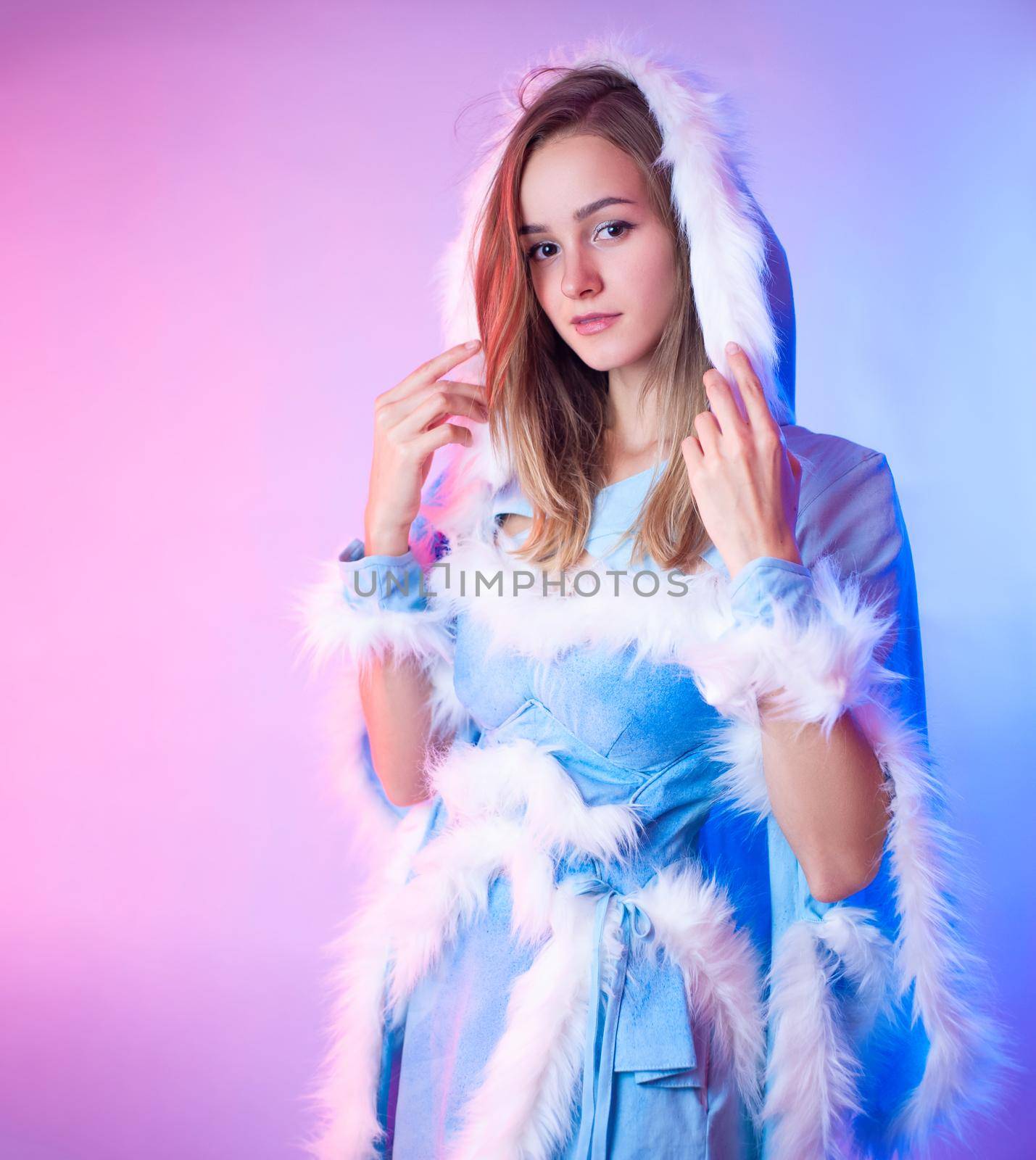 woman in a blue snow maiden costume poses on a light neon background