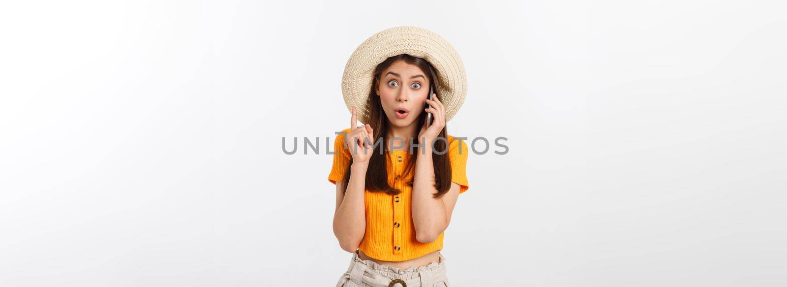 Picture of surprised voyage girl looking shock while holding phone in hands isolated over grey background.