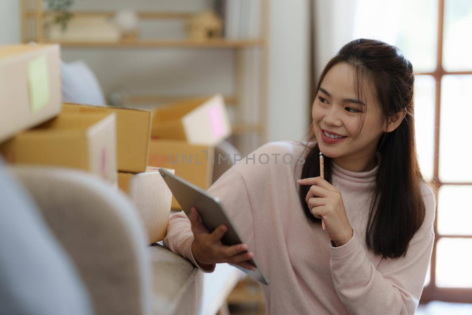 Asian SME business woman checking order working at home office. online shopping concept.