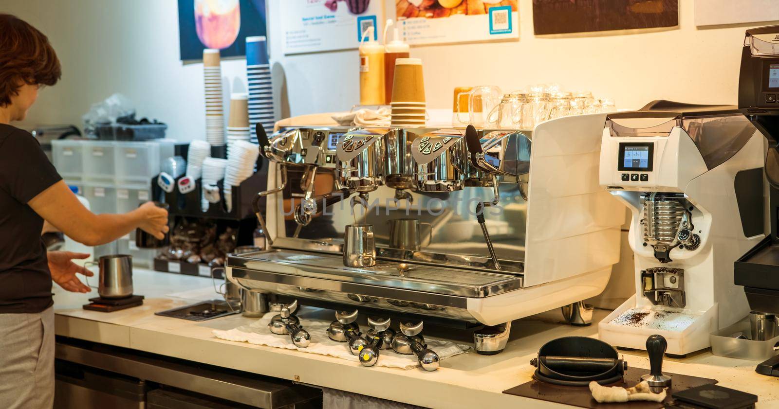 Barista working with coffee machine in coffee shop. Coffee maker for make espresso, americano, latte, and cappuccino. Counter bar of coffee shop. Modern tool for barista. Beverage service business. by Fahroni