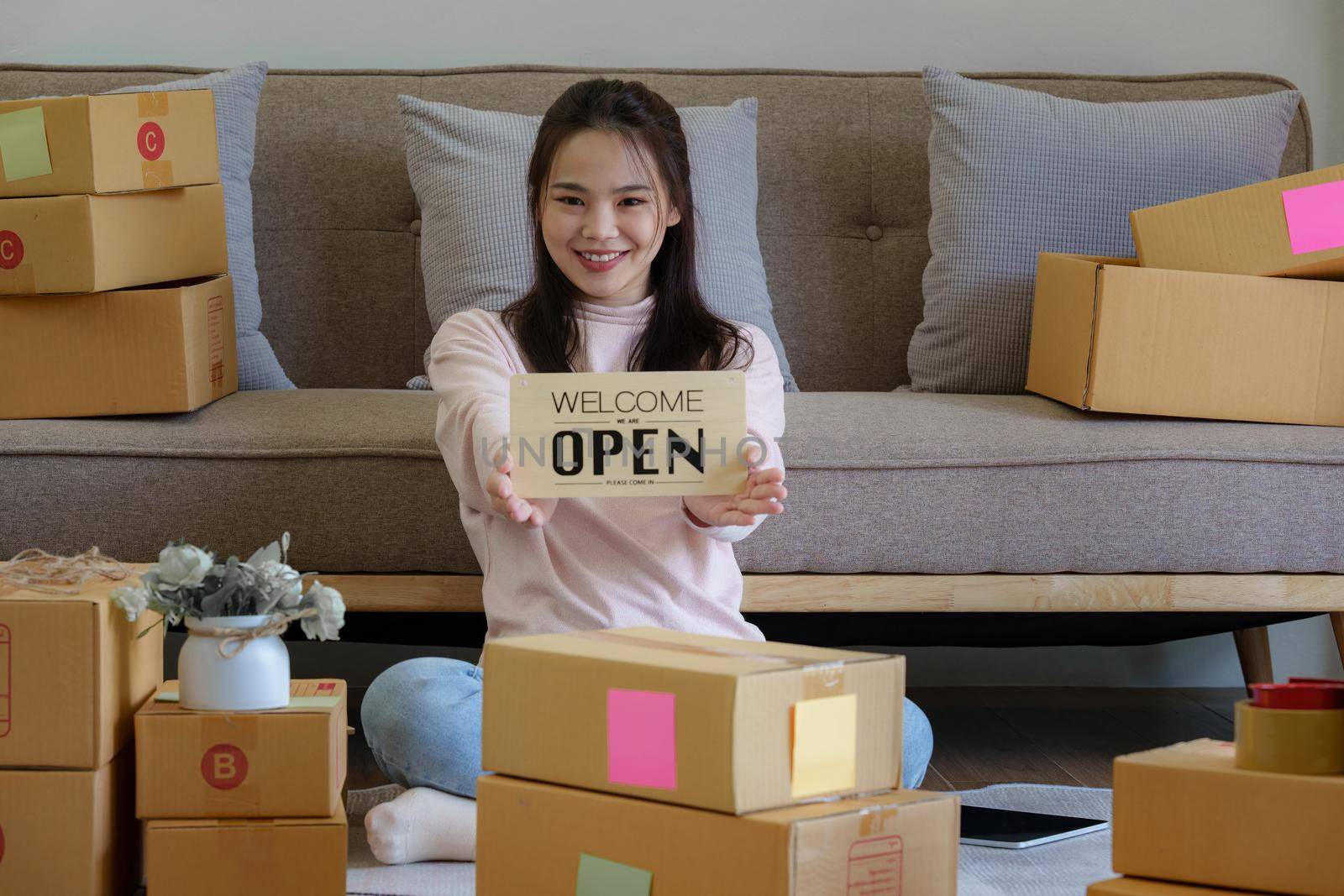Asian SME business woman showing Open Sign and welcome customer.