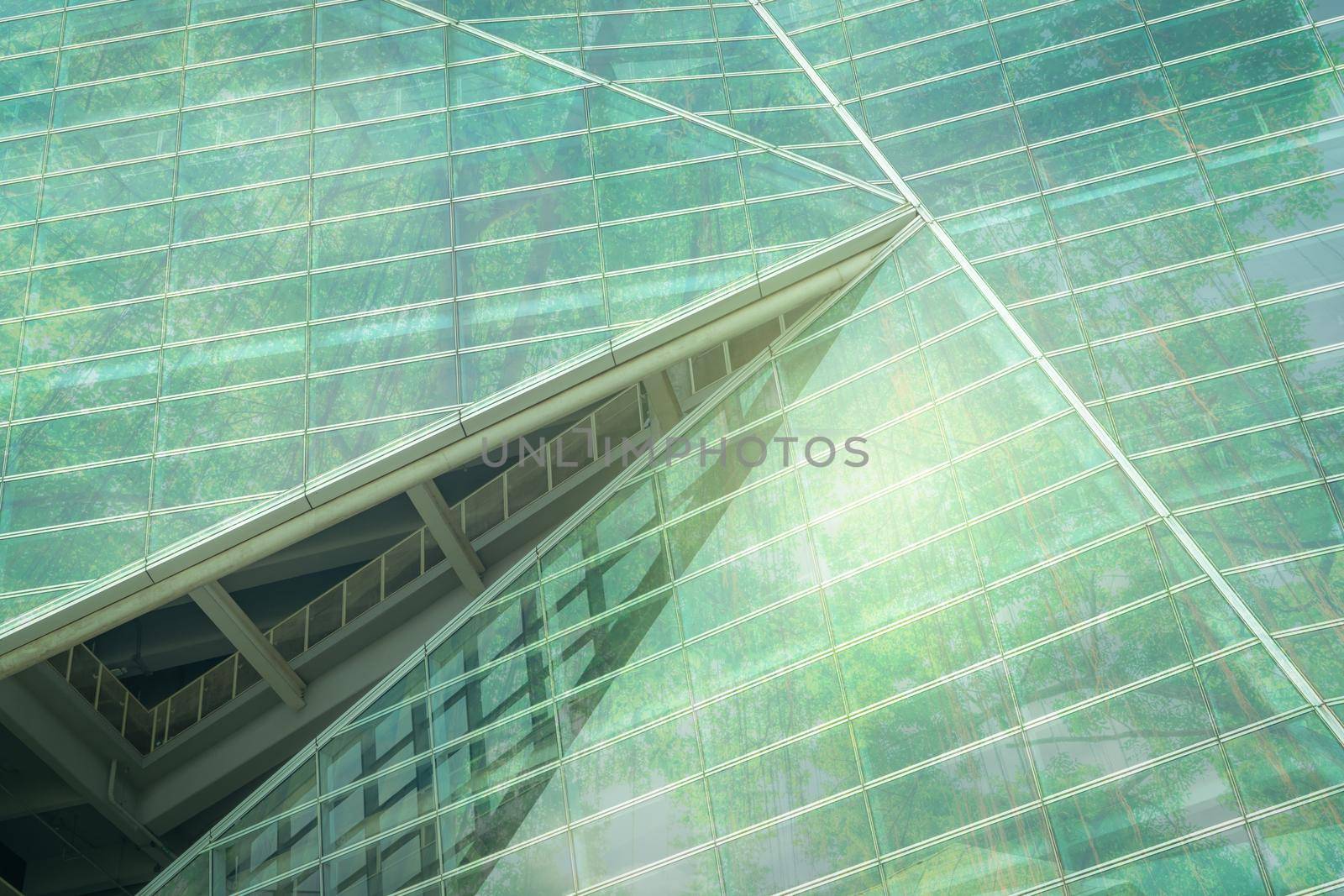 Sustainble green building. Eco-friendly building. Sustainable glass office building with tree for reducing carbon dioxide. Office with green environment. Corporate building reduce CO2. Safety glass.