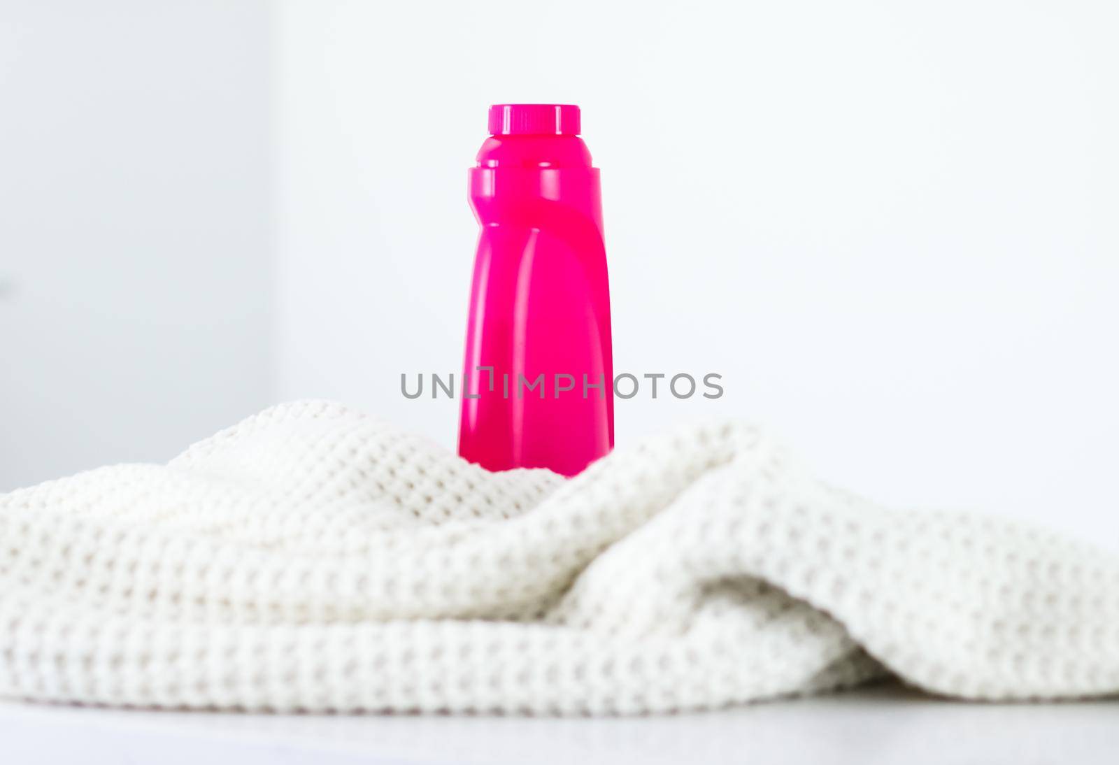 Housekeeping, fabric textures and handmade knitwear concept - Warm knitted clothes and liquid laundry detergent