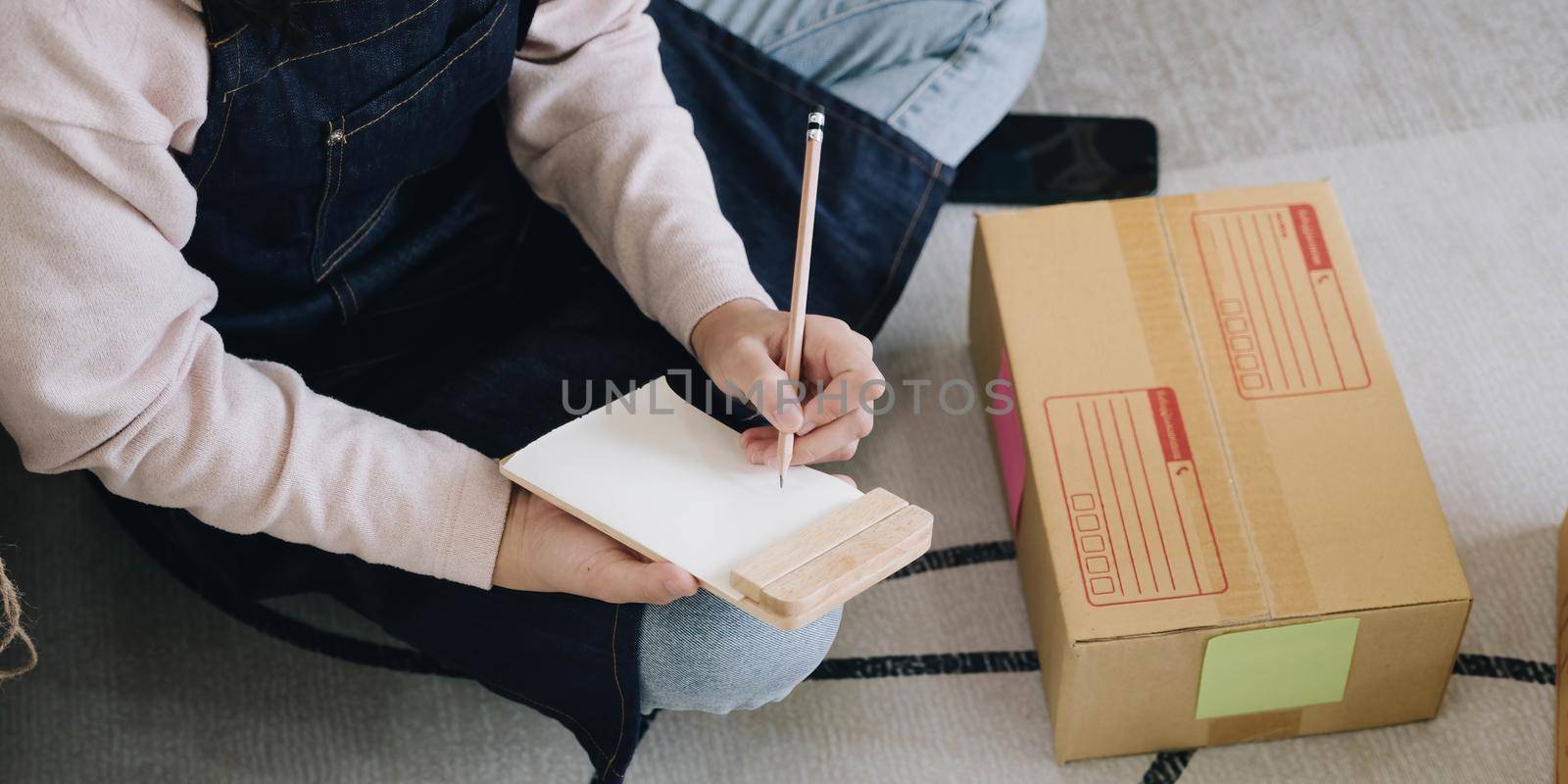 Startup Entrepreneurship Small Business SME Freelance Young lady working at home with boxes on the floor and laptop online Marketing Packaging SME