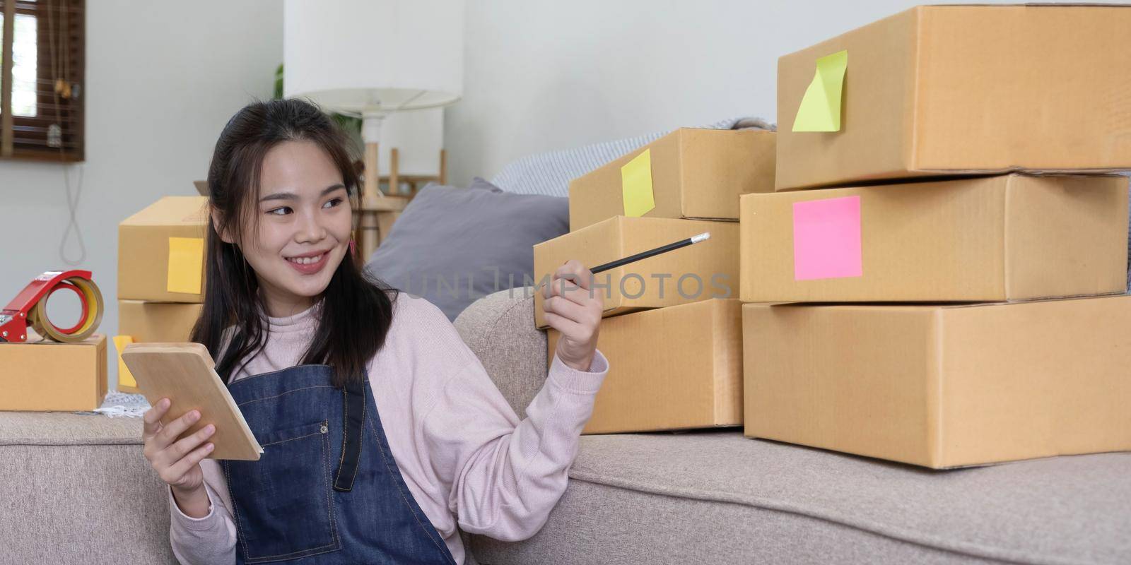 Portrait of Starting small businesses owners female entrepreneurs working on receipt box and check online orders to prepare to pack the boxes, sell to customers, sme business ideas online. by wichayada