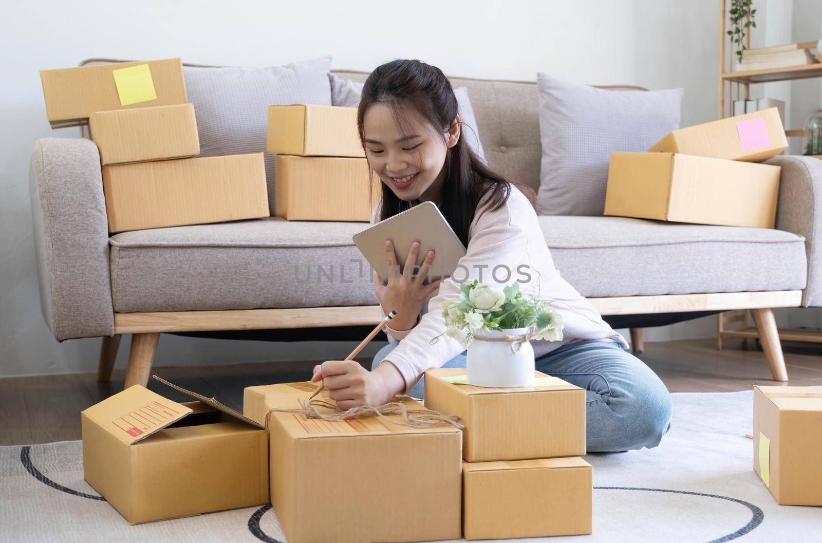 Starting small businesses SME owners female entrepreneurs check online orders to prepare to pack the boxes, sell to customers, sme business ideas online. by wichayada