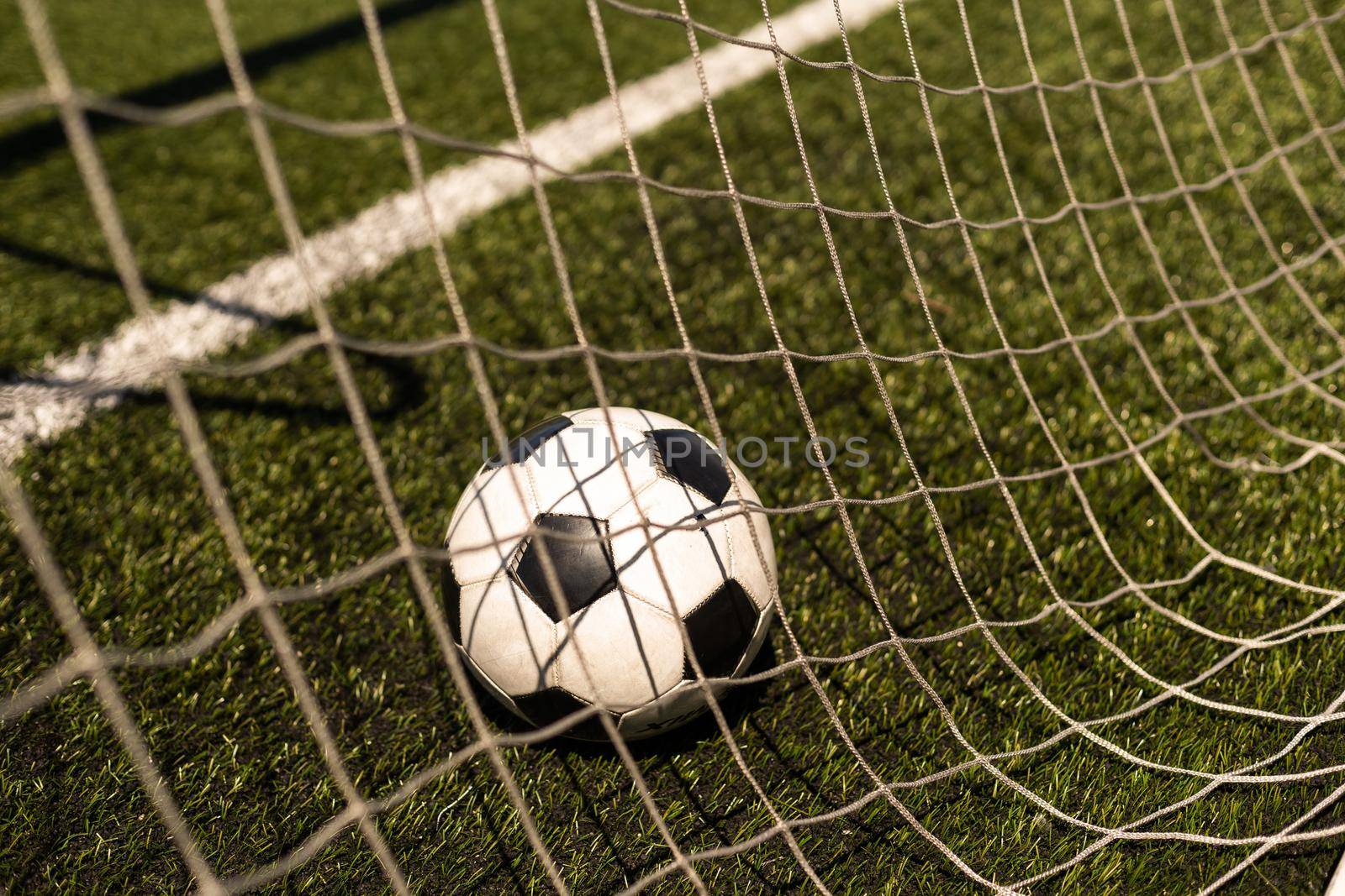 white and black soccer ball on green grass and stadium background. sports betting idea