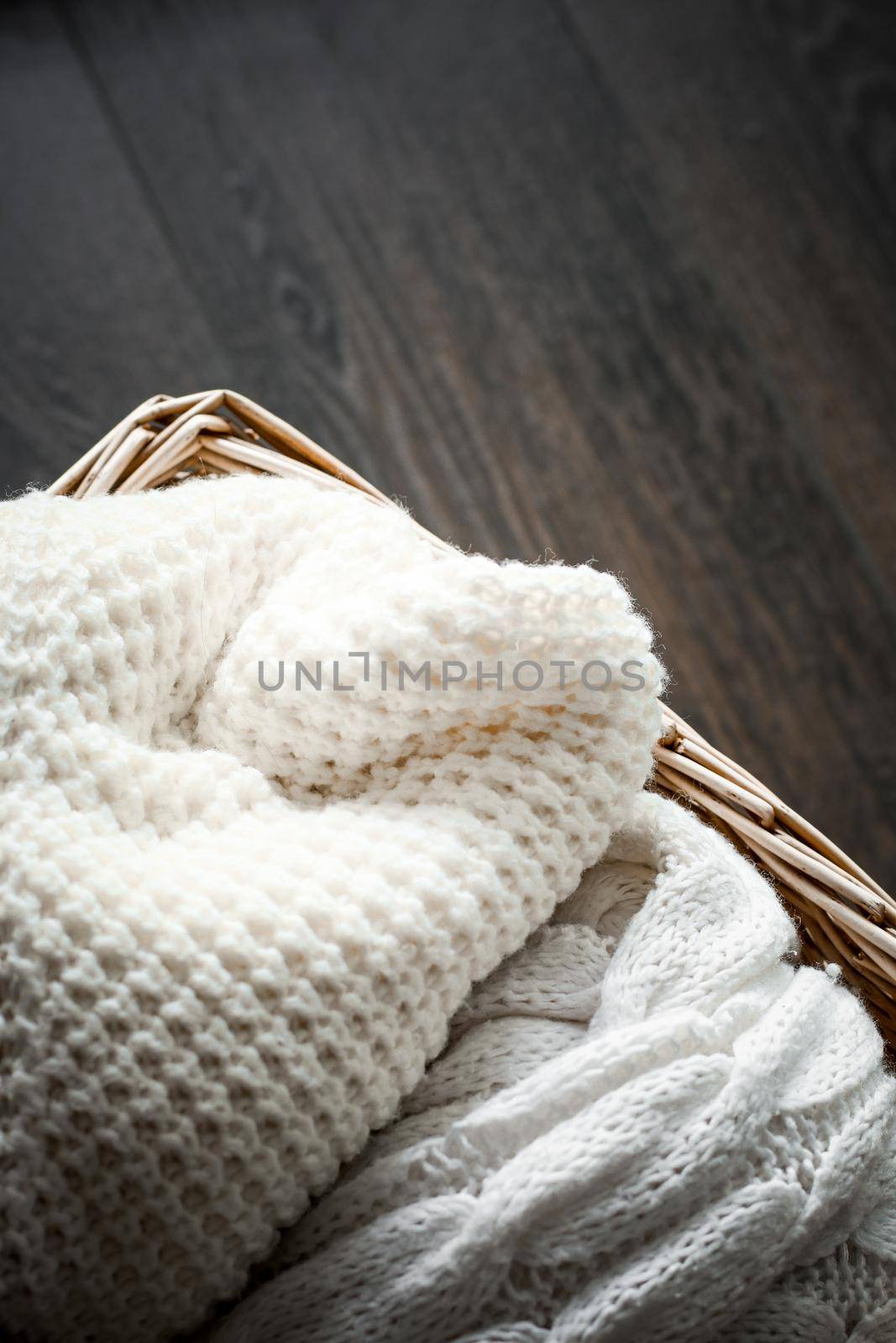 Knitted winter clothes in a basket by Anneleven