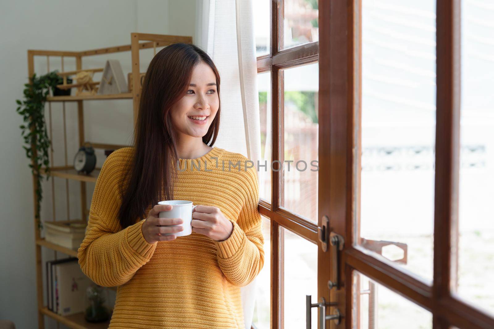 Portrait of an Asian businesswoman or business owner taking a coffee break while working in the office.