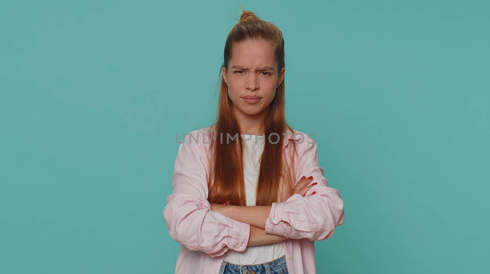 Dissatisfied pretty teenager girl asking reason of failure, expressing disbelief irritation, feeling bored, disappointed in result, bad news. Young child kid isolated alone on blue studio background