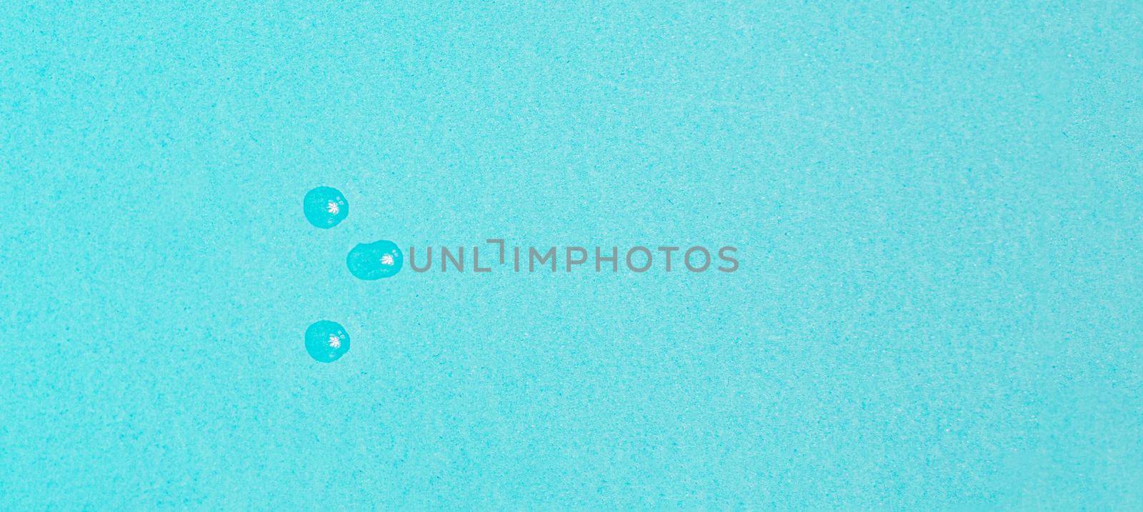 drops of vaccine on pastel blue background from above by Ciorba