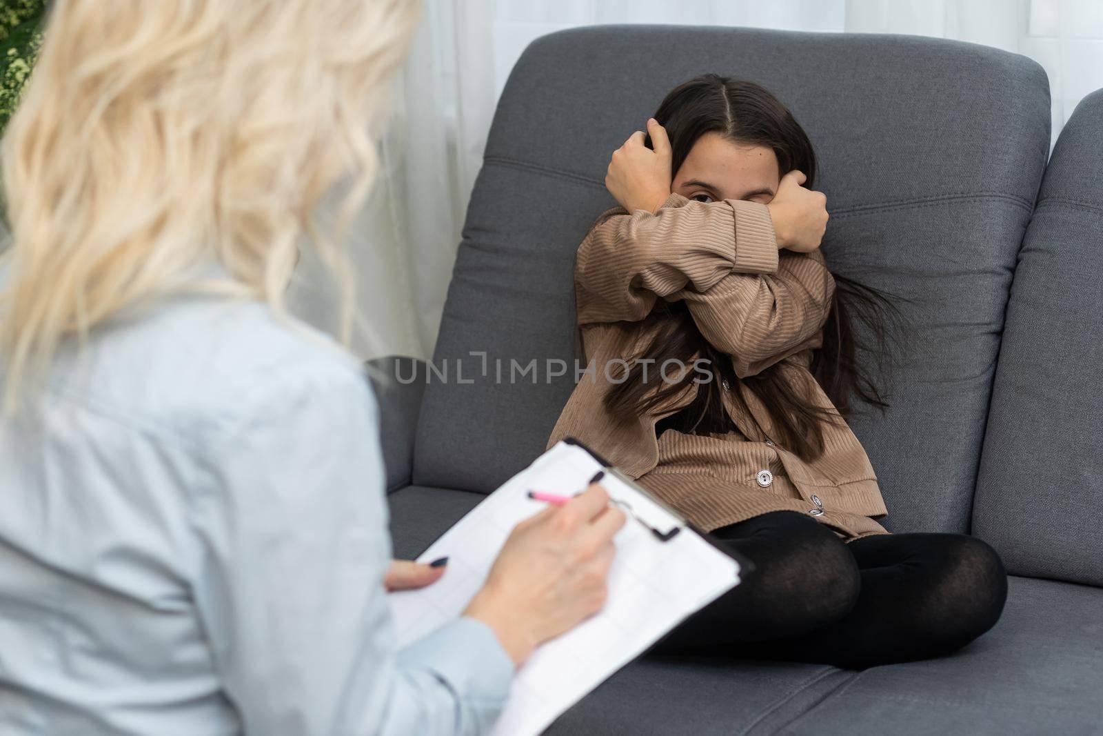 Female psychologist working with little girl at home.