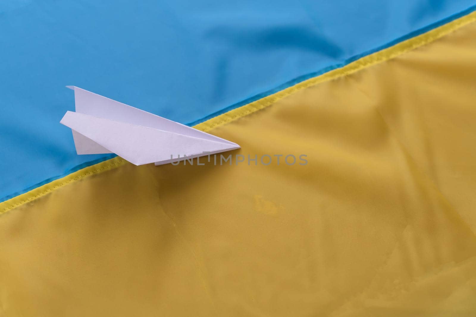 paper airplane on the background of the flag of Ukraine.
