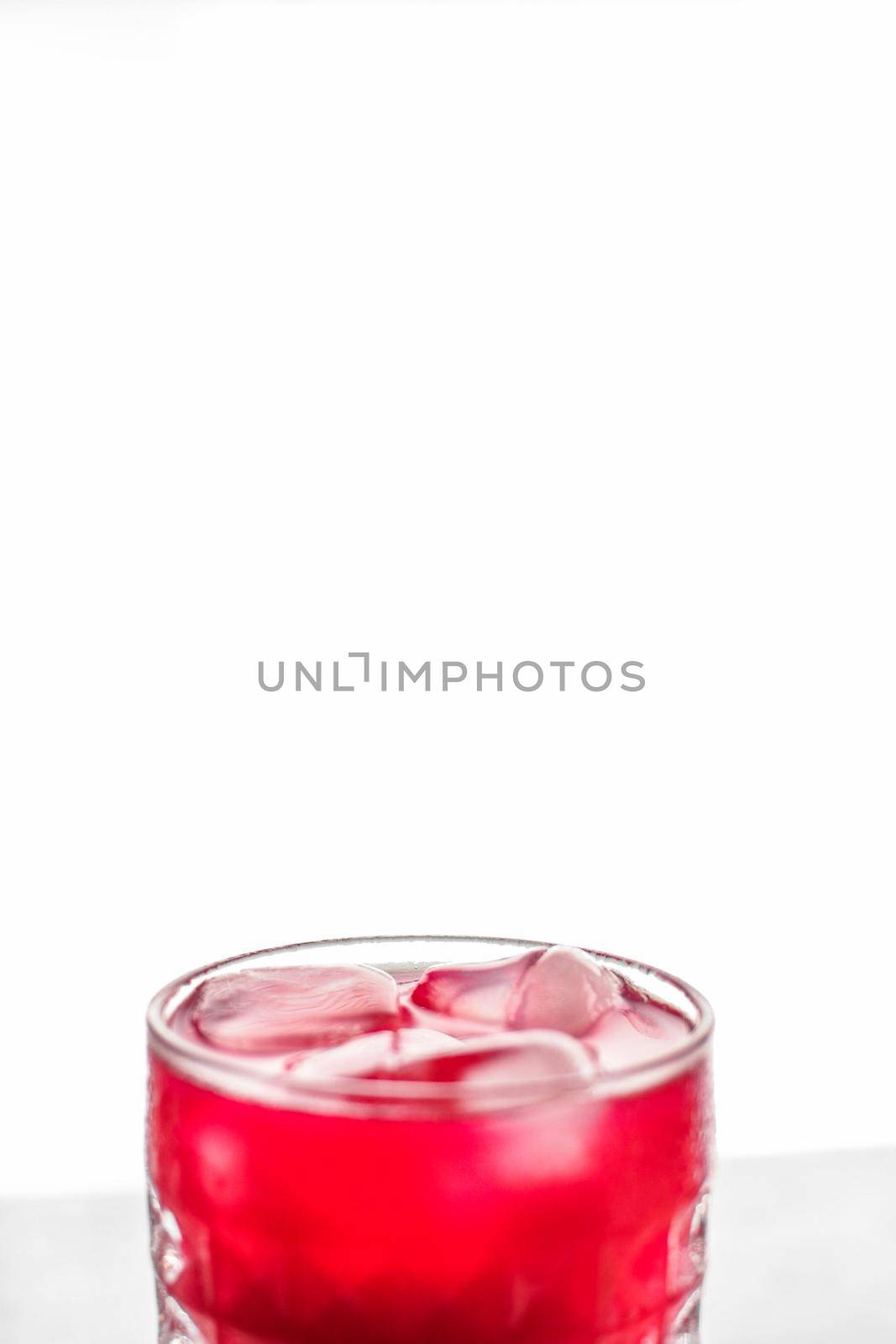 Alcohol drink, refreshment and cold beverage concept - Glass of red cocktail with ice, luxury bar party