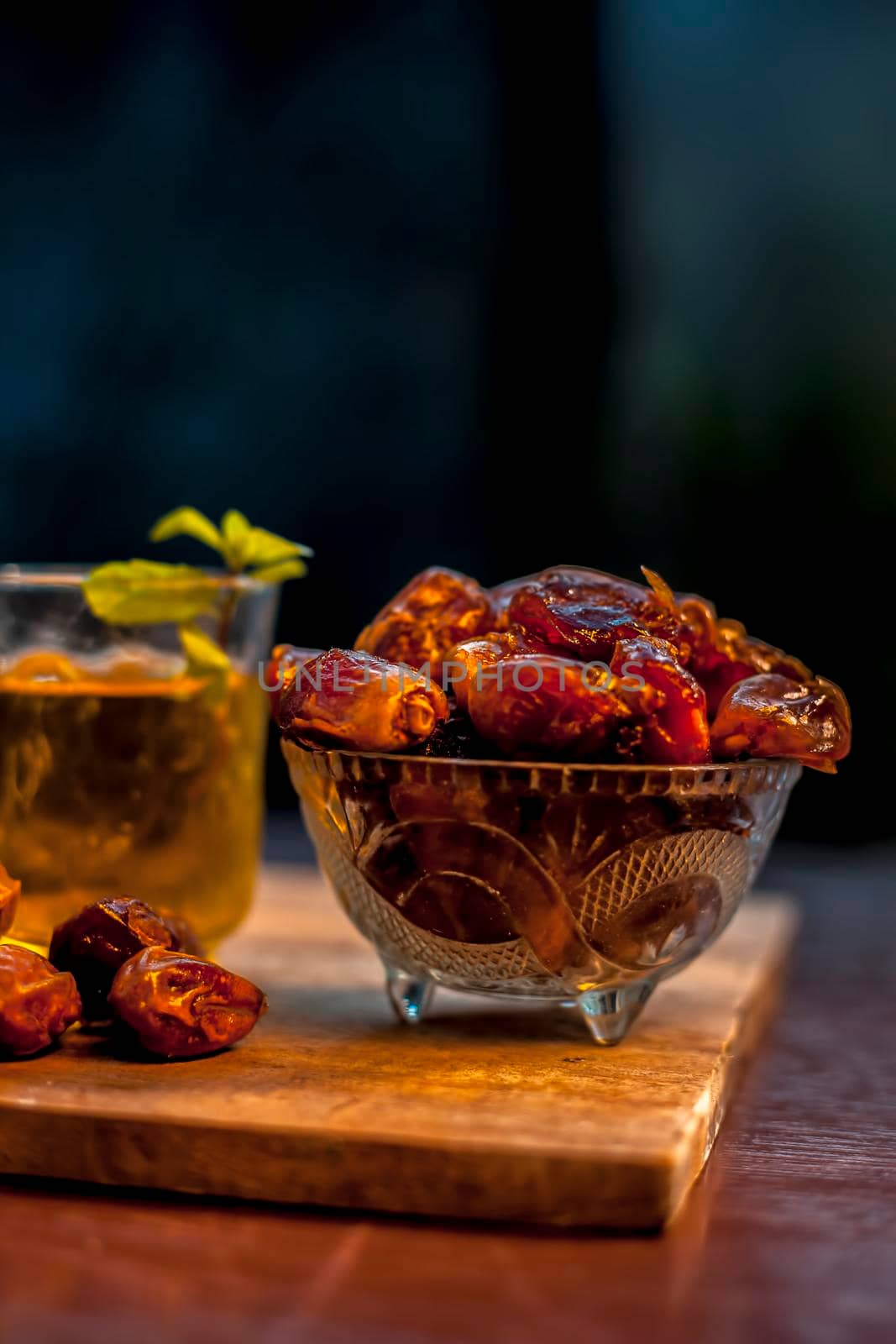 Close up of raw dates along with its syrup in a glass with some mint leaves on it which helps in weight loss, constipation aid and promotes heart health.