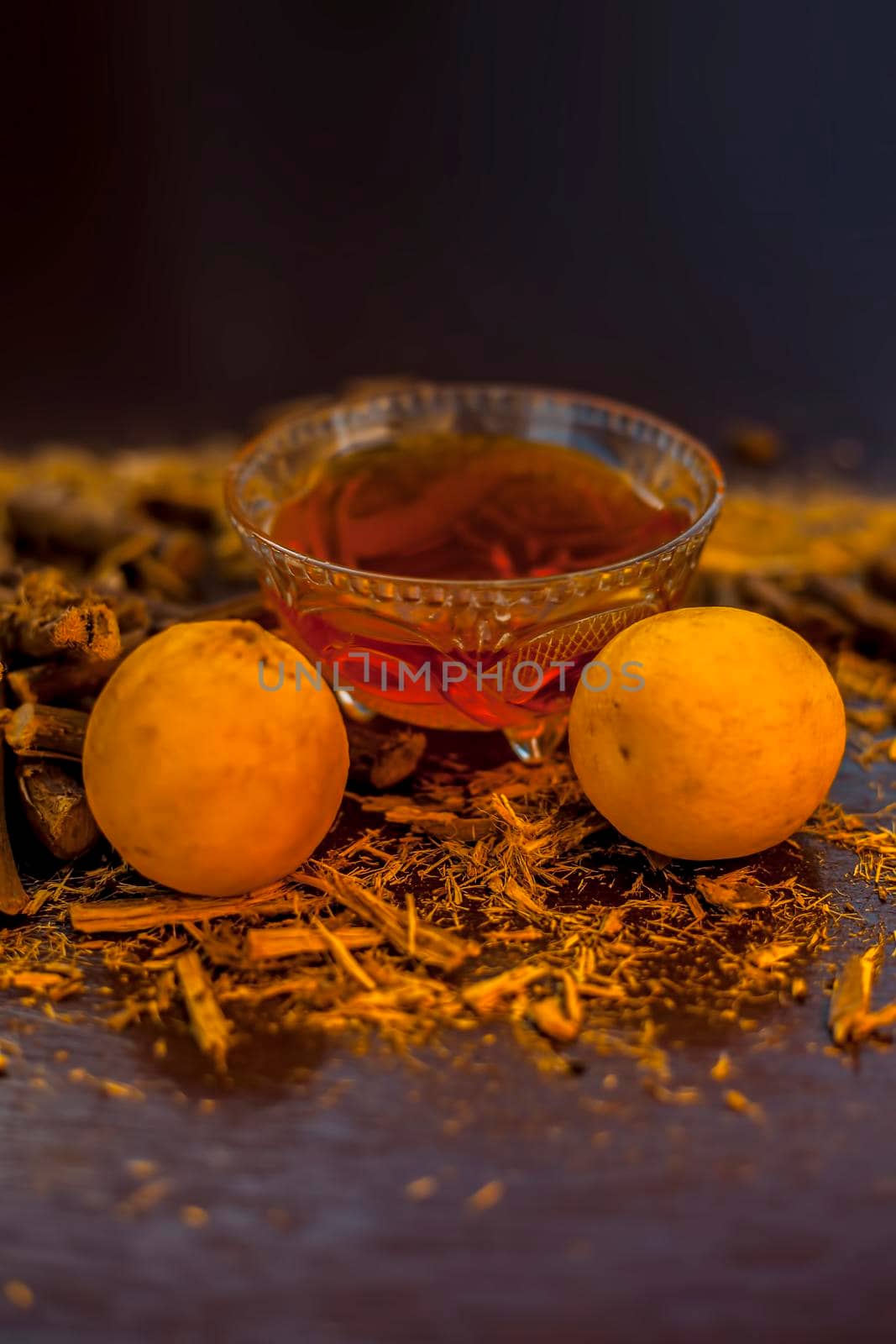Best ayurvedic skin whitening face mask on brown colored surface with warm colors consisting of licorice, lemon juice, and honey. Shot of mulethi, honey, and lemons on the surface, by mirzamlk