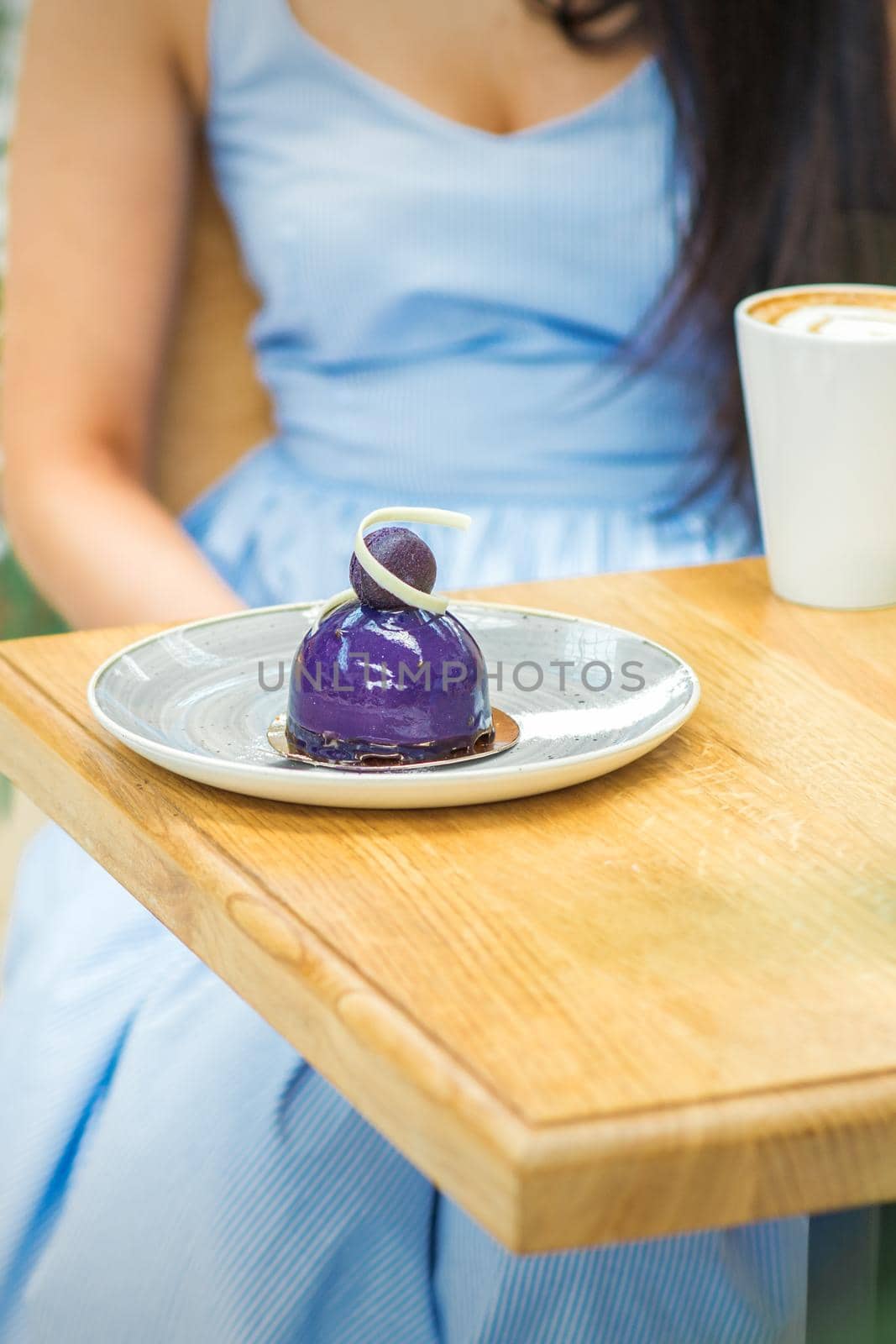 Young woman sitting at the table in cafe by okskukuruza