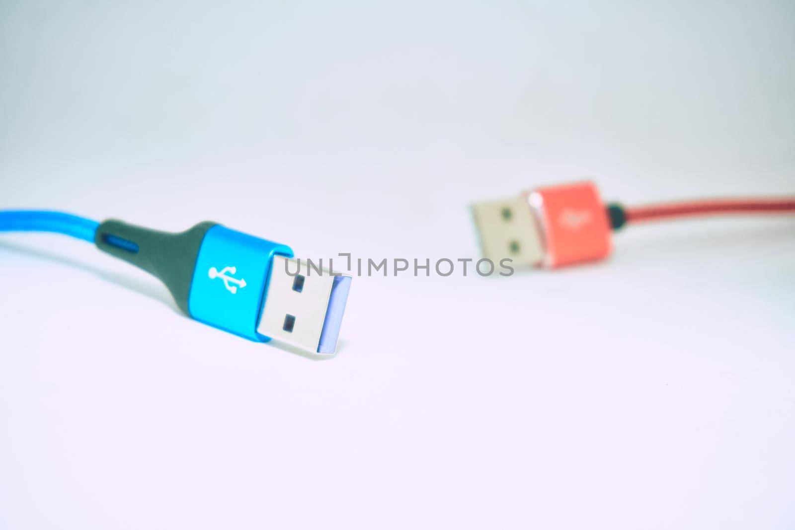 bring together or into contact so that a real or notional link is established. Blue red Universal Serial Bus cables isolated on a gray background. High quality photo