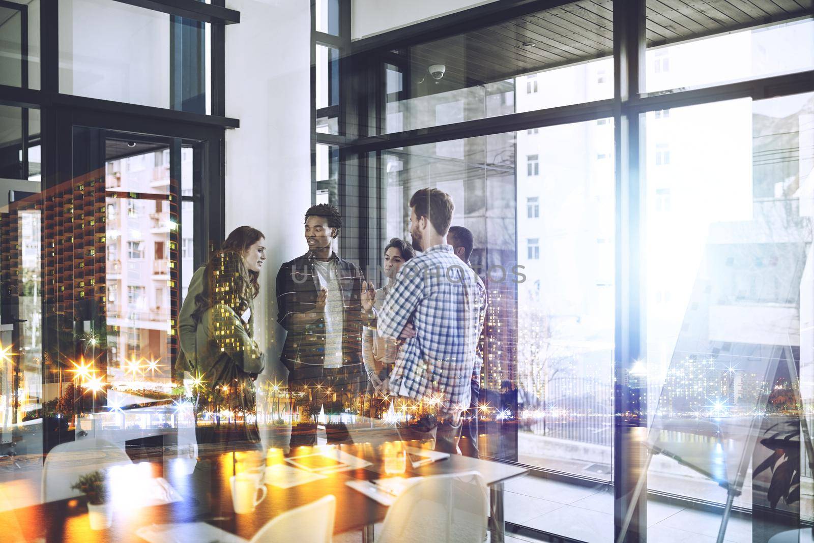 Great minds at work. Multiple exposure shot of businesspeople superimposed over a cityscape