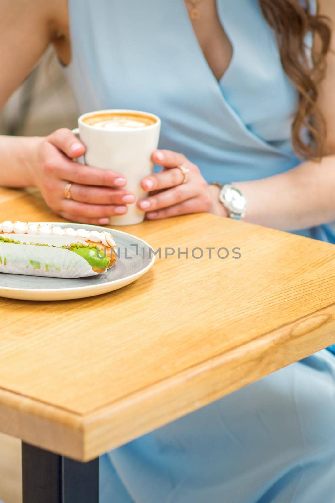 Young woman sitting at the table in cafe by okskukuruza