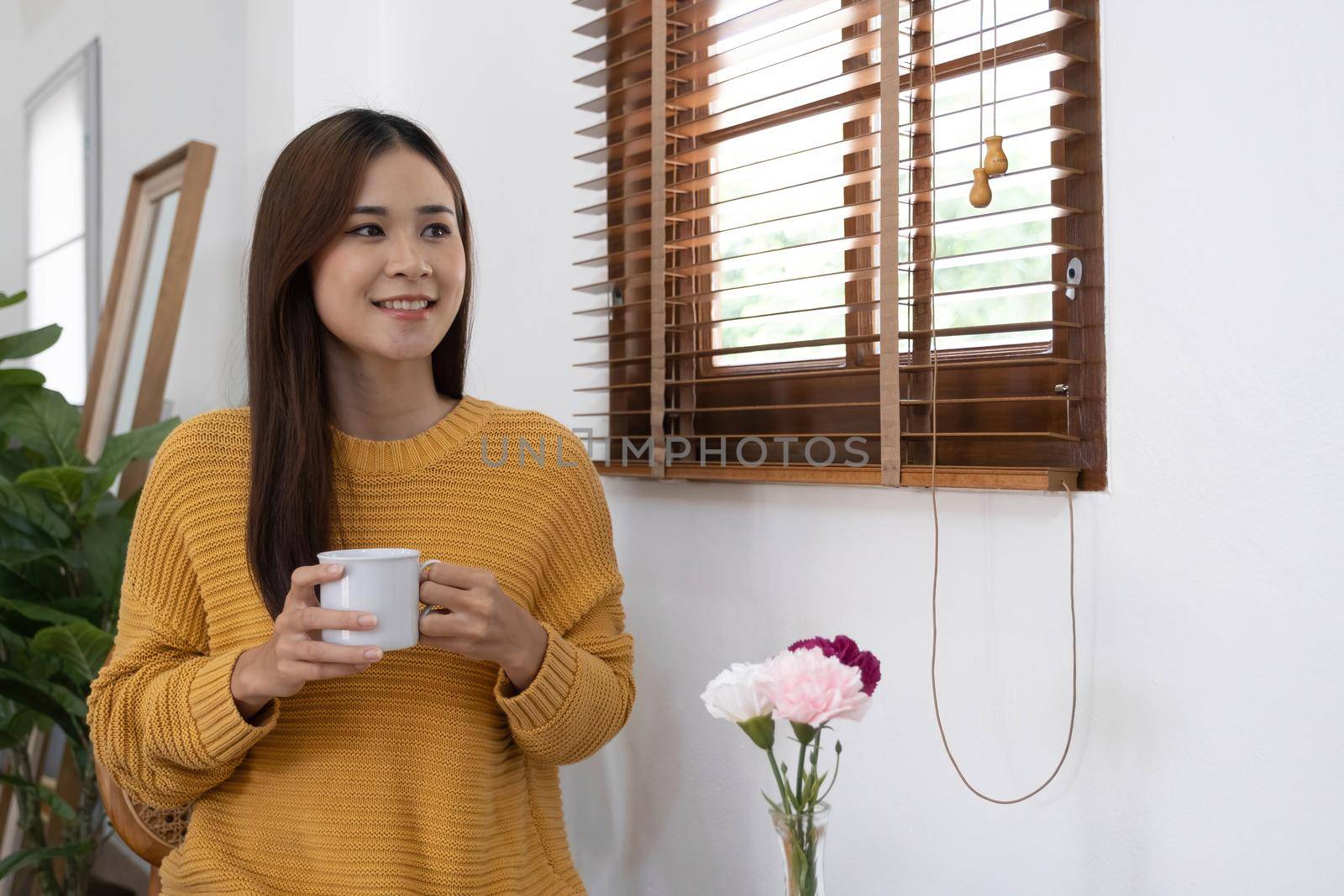 Young Girl Sitting In Modern Chair, Enjoying Coffee In Front Of Window, Side View.