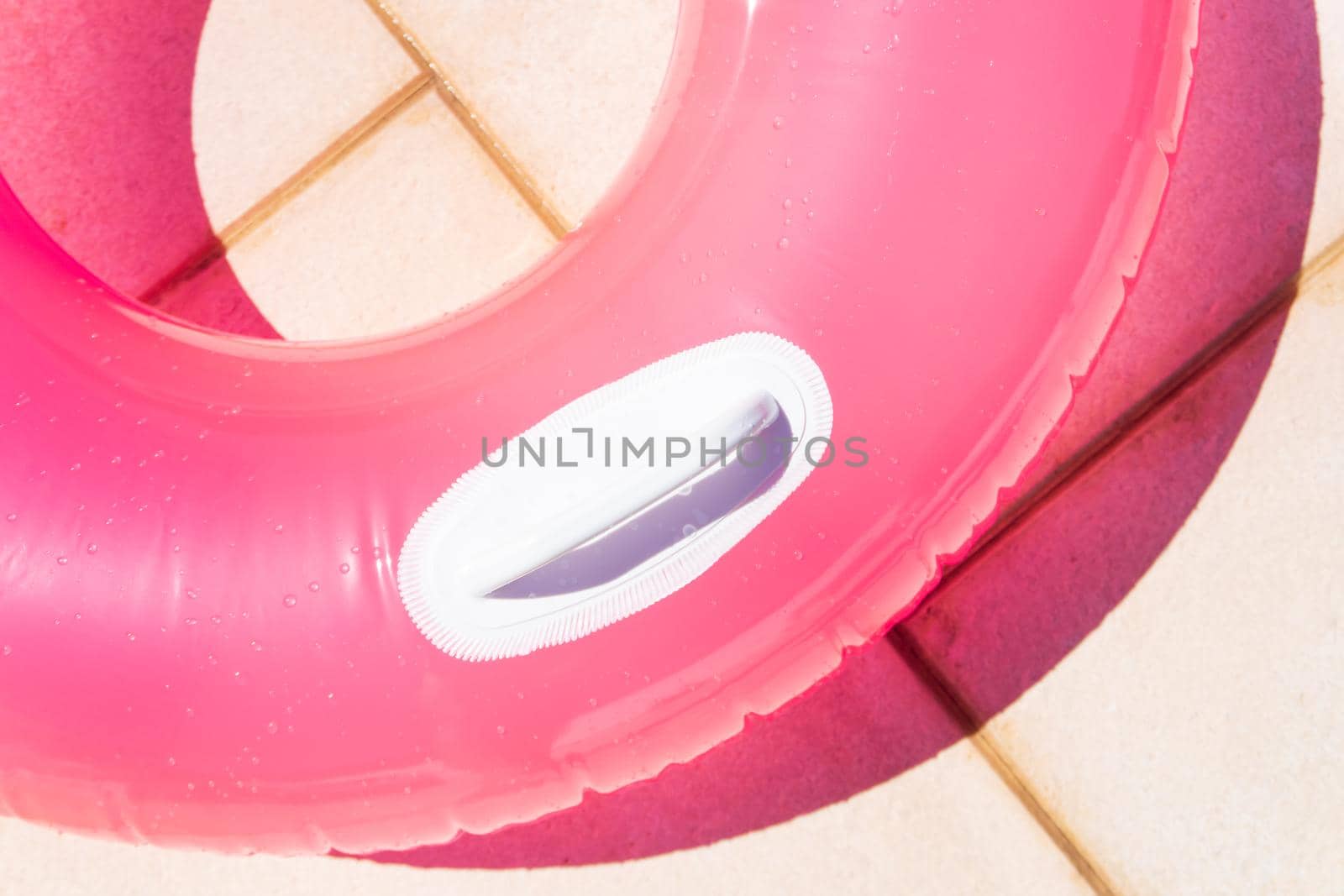 Translucent pink swim ring under the bright sun background