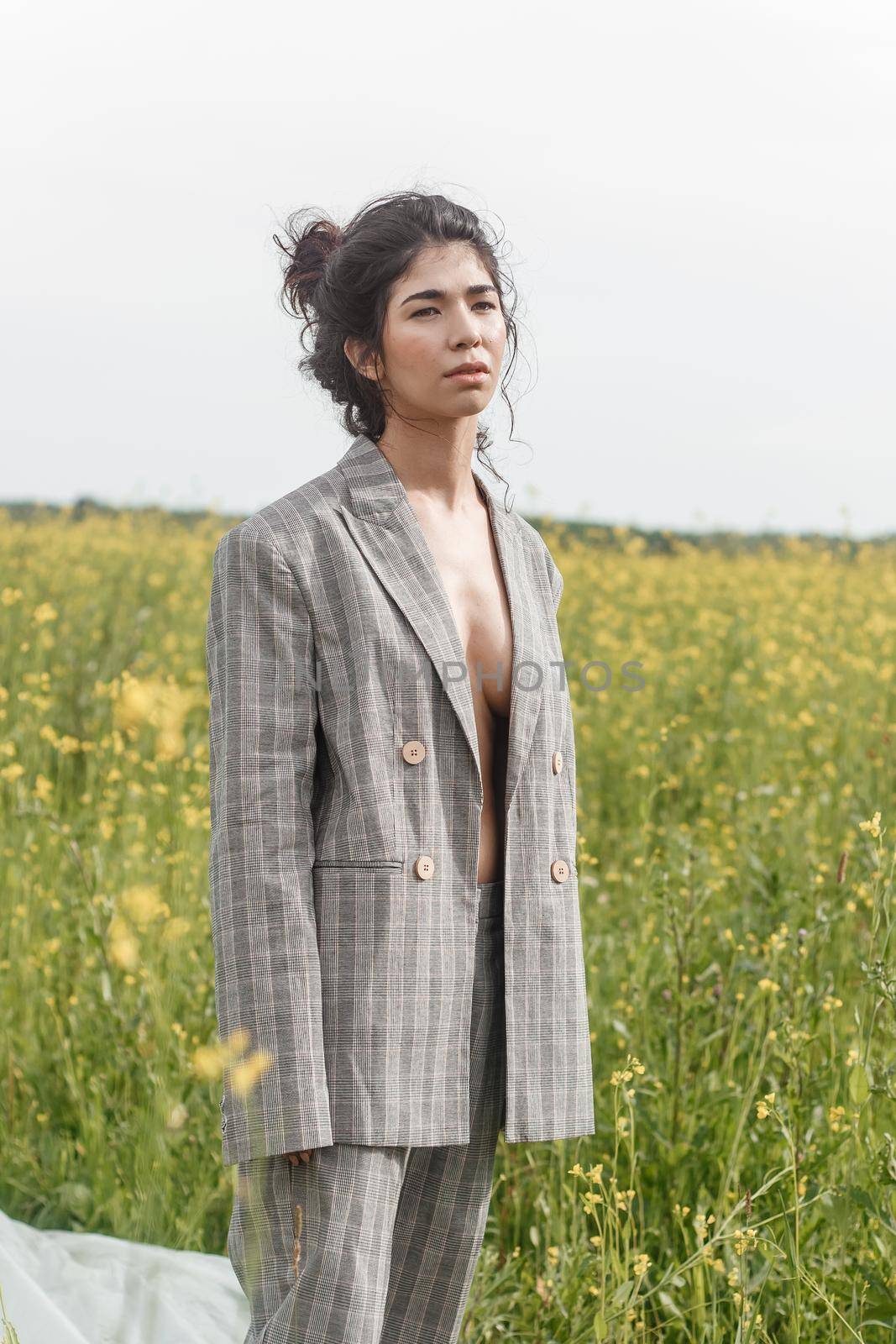 An Asian model poses in a field of yellow flowers for a clothing brand, polyethylene is the main props for a photo shoot. by Annu1tochka