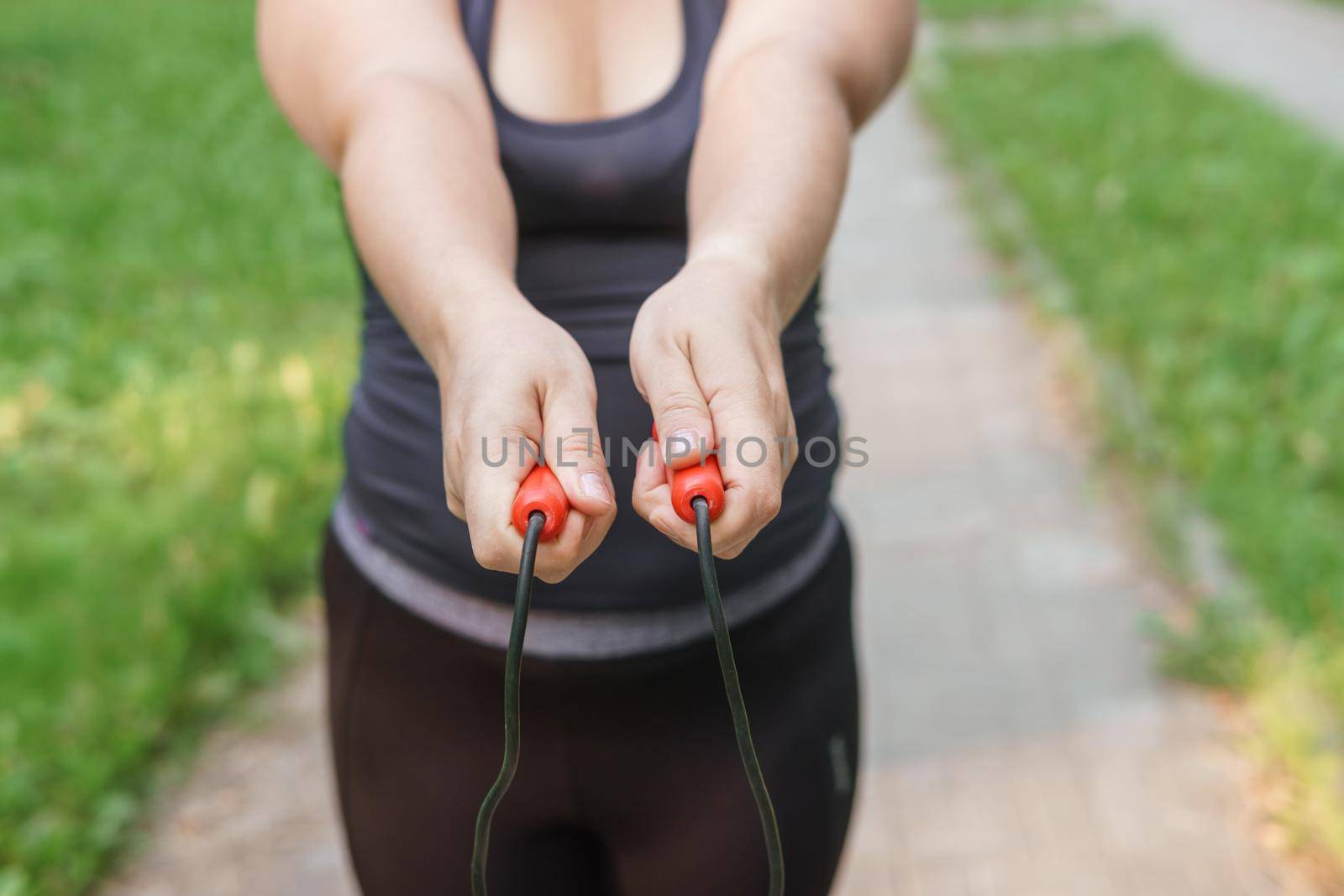 A charming brunette woman plus-size body positive practices sports in nature.