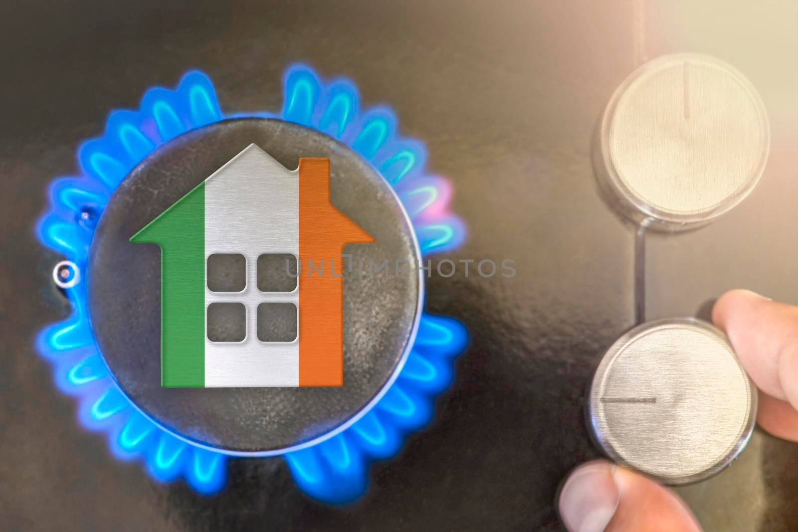 Heating season or gas use in Ireland. Concept, model of a house stands near the flame of a gas boiler on a black background. The cost of using natural gas in Ireland