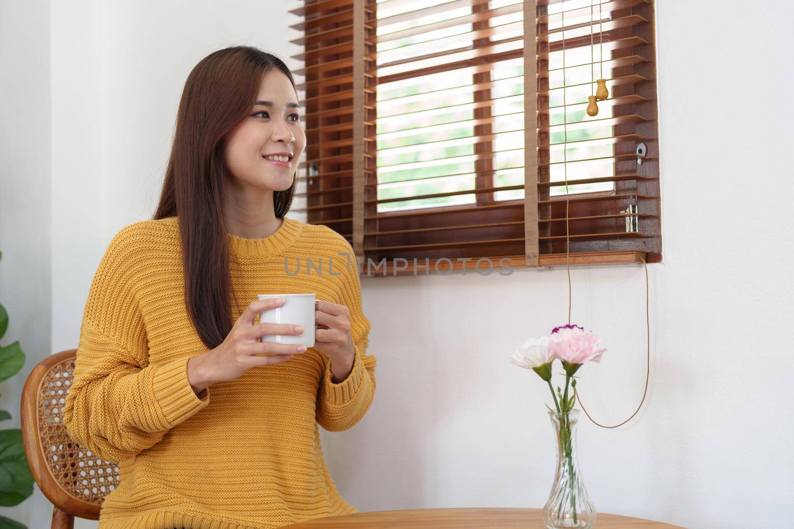 Portrait of an Asian businesswoman or business owner taking a coffee break while working in the office.