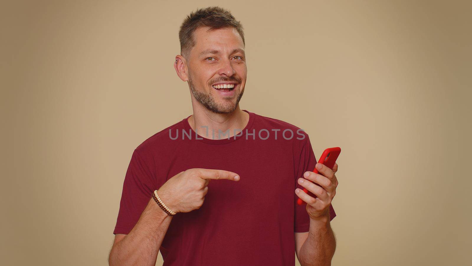 Handsome young male man using smartphone typing new post on web, browsing, searching, addiction of social networks, show thumbs up like, positive feedback, recommends wifi cellular connection 5G
