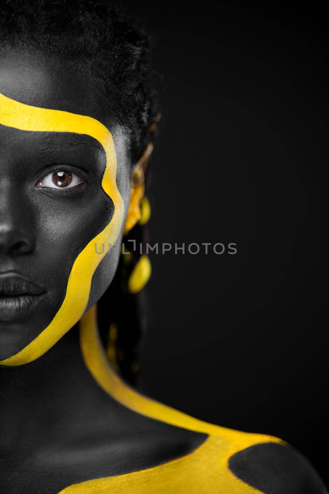 The Art Face. Black and yellow body paint on african woman. Abstract creative portrait. Bright fashion makeup on the girl. by MikeOrlov