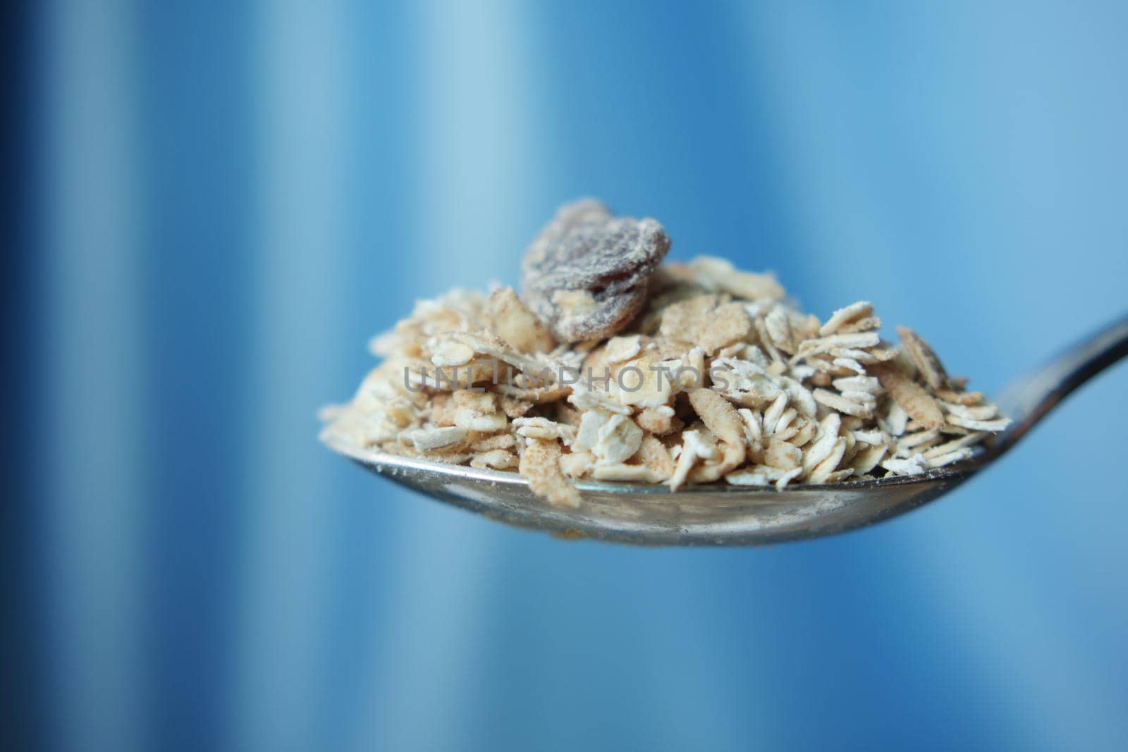 side view of oats flakes on a spoon ,