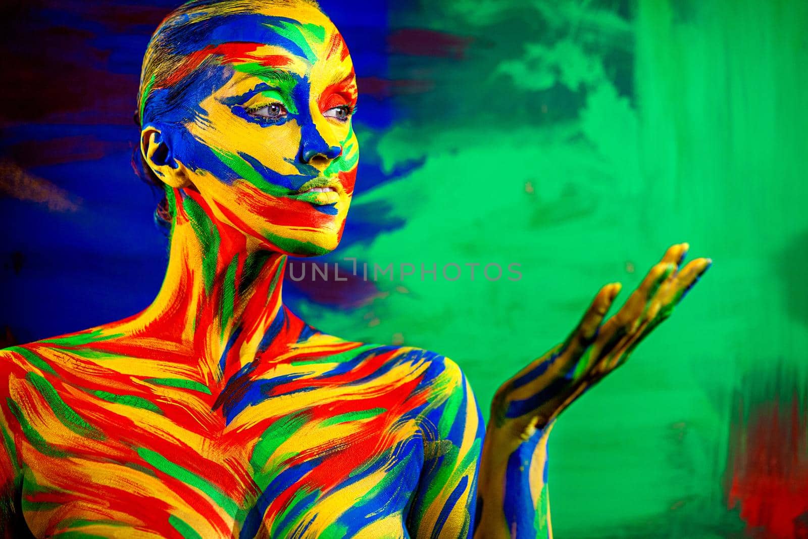 Color art face for inspiration. Abstract portrait of the bright beautiful girl with colorful make-up and bodyart. Woman pointing to looking right. by MikeOrlov