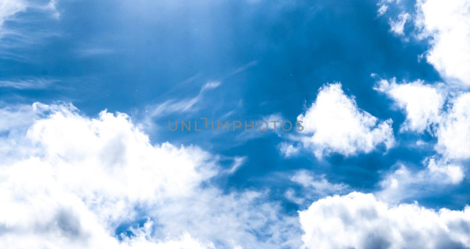 Blue sky background, white clouds and bright sunlight by Anneleven