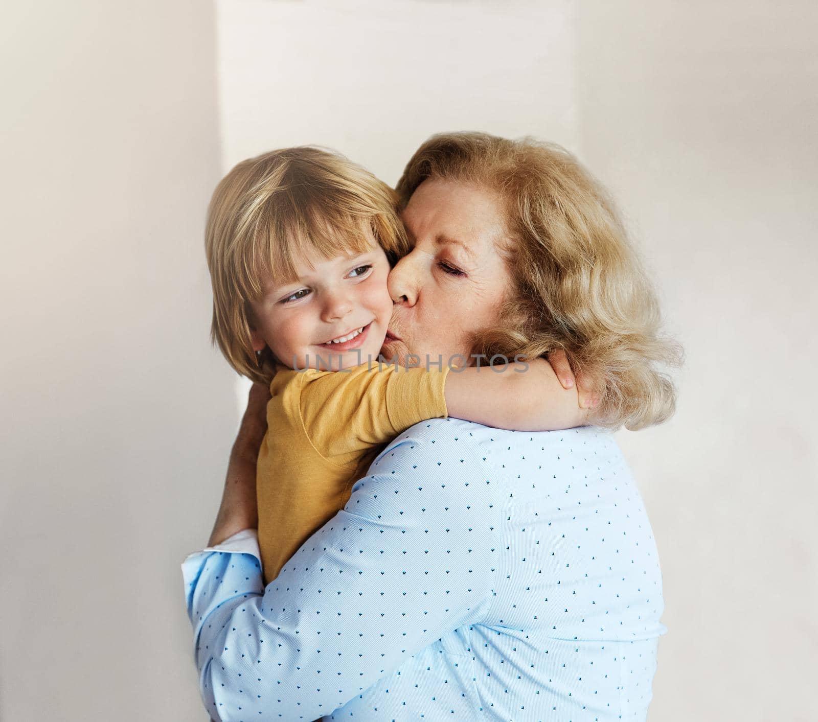 Portrait of grandmother and grandsonor having fun hugging and bonding together at home