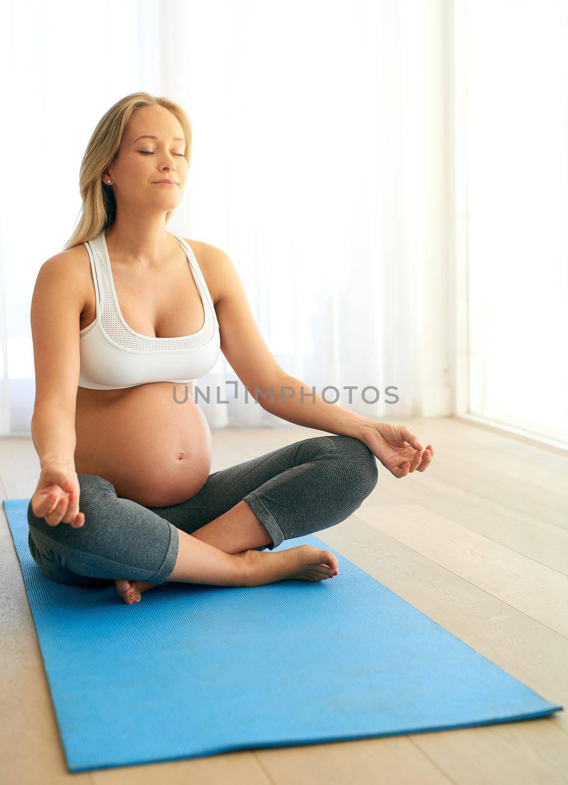 All is well with me and my baby. a pregnant woman meditating on an exercise mat at home