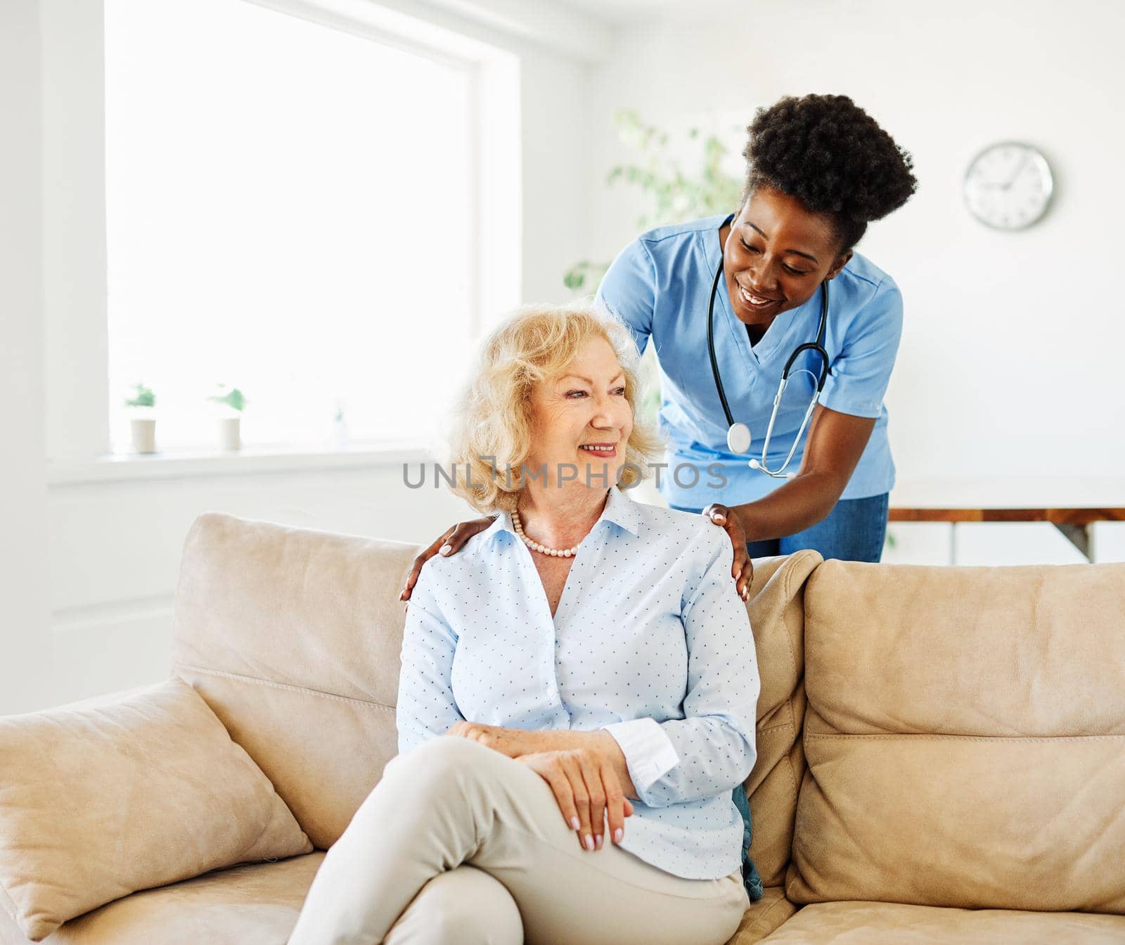 Doctor or nurse caregiver with senior woman at home or nursing home