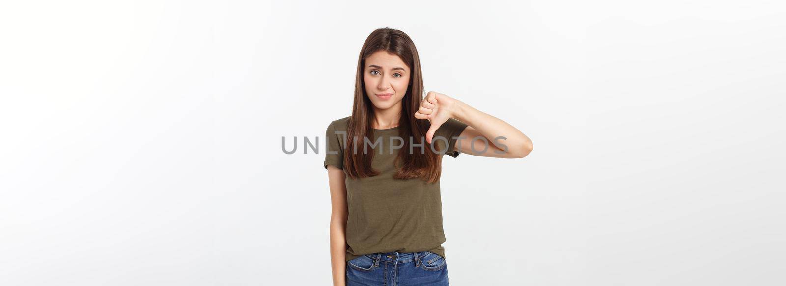 Image of resentful woman with long dark hair showing thumbs down isolated over gray background