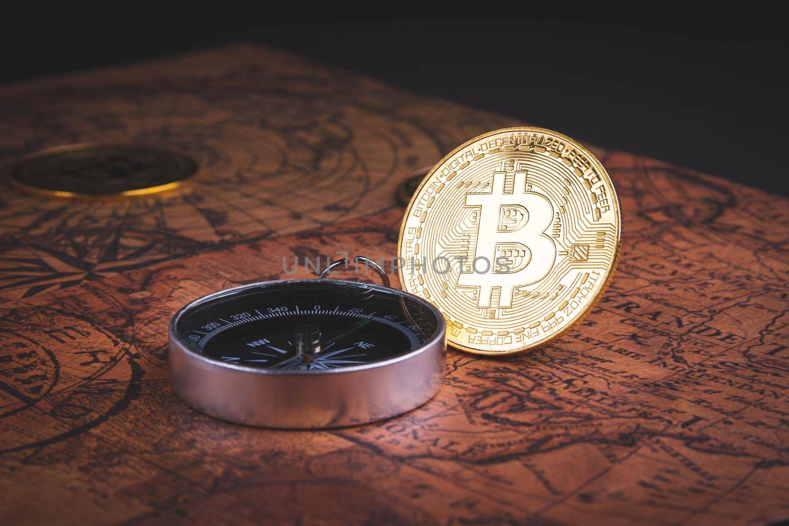 Compass and bitcoin. Travel and cryptocurrencies. Buying tickets with bitcoins. Alternative currency and travel. Coin and compass on the map.