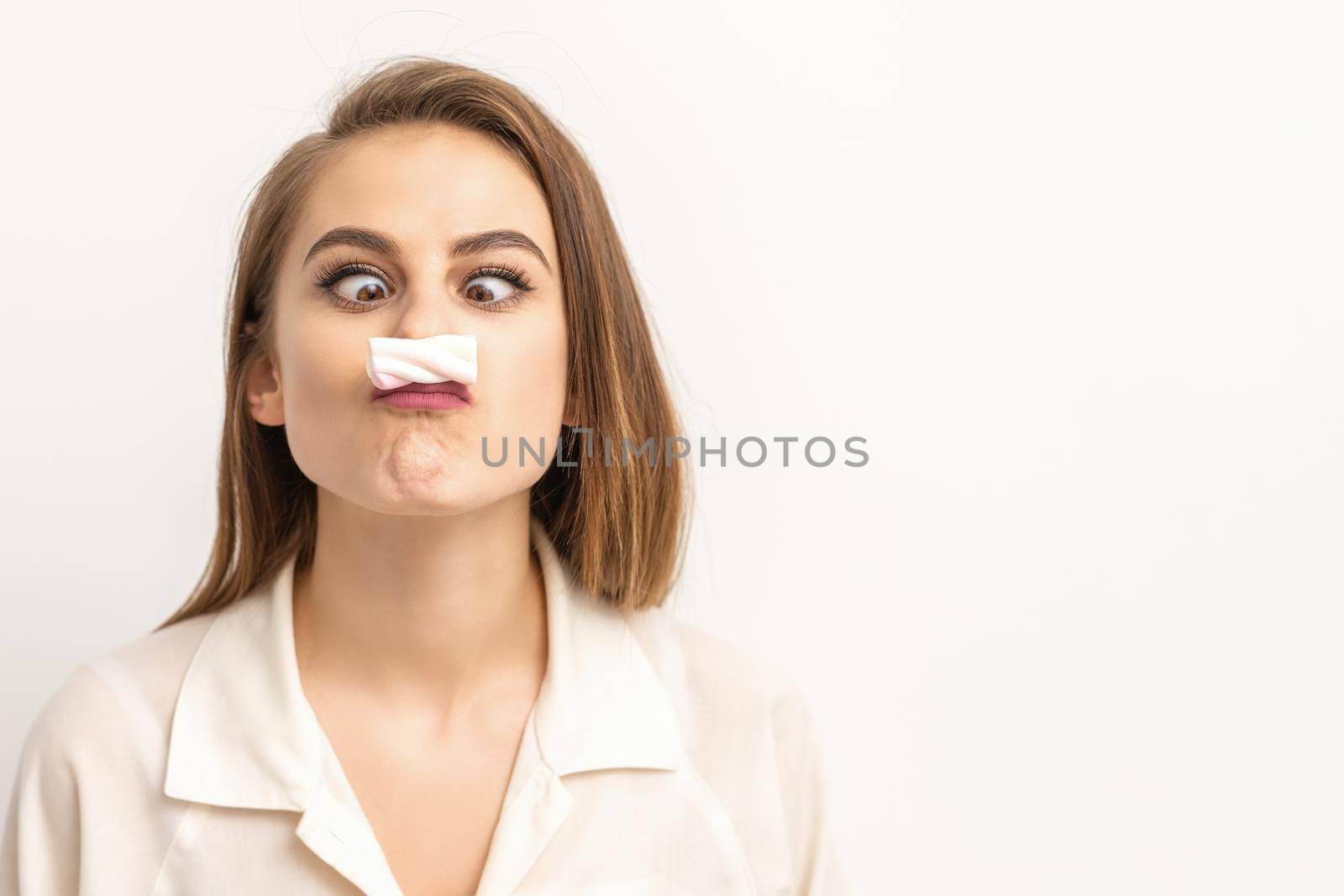 Young funny woman with sweet candy marshmallow-like mustache over white background. Depilation and epilation concept