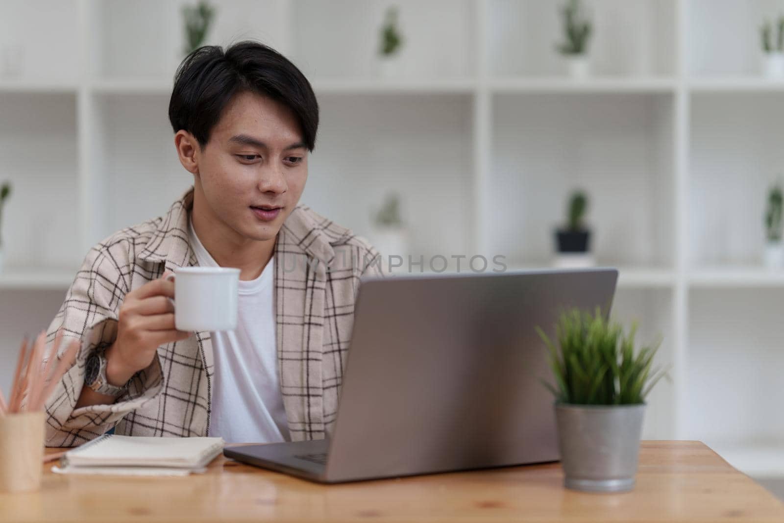 Asian man using laptop computer working at office. Creative and new idea concpet.