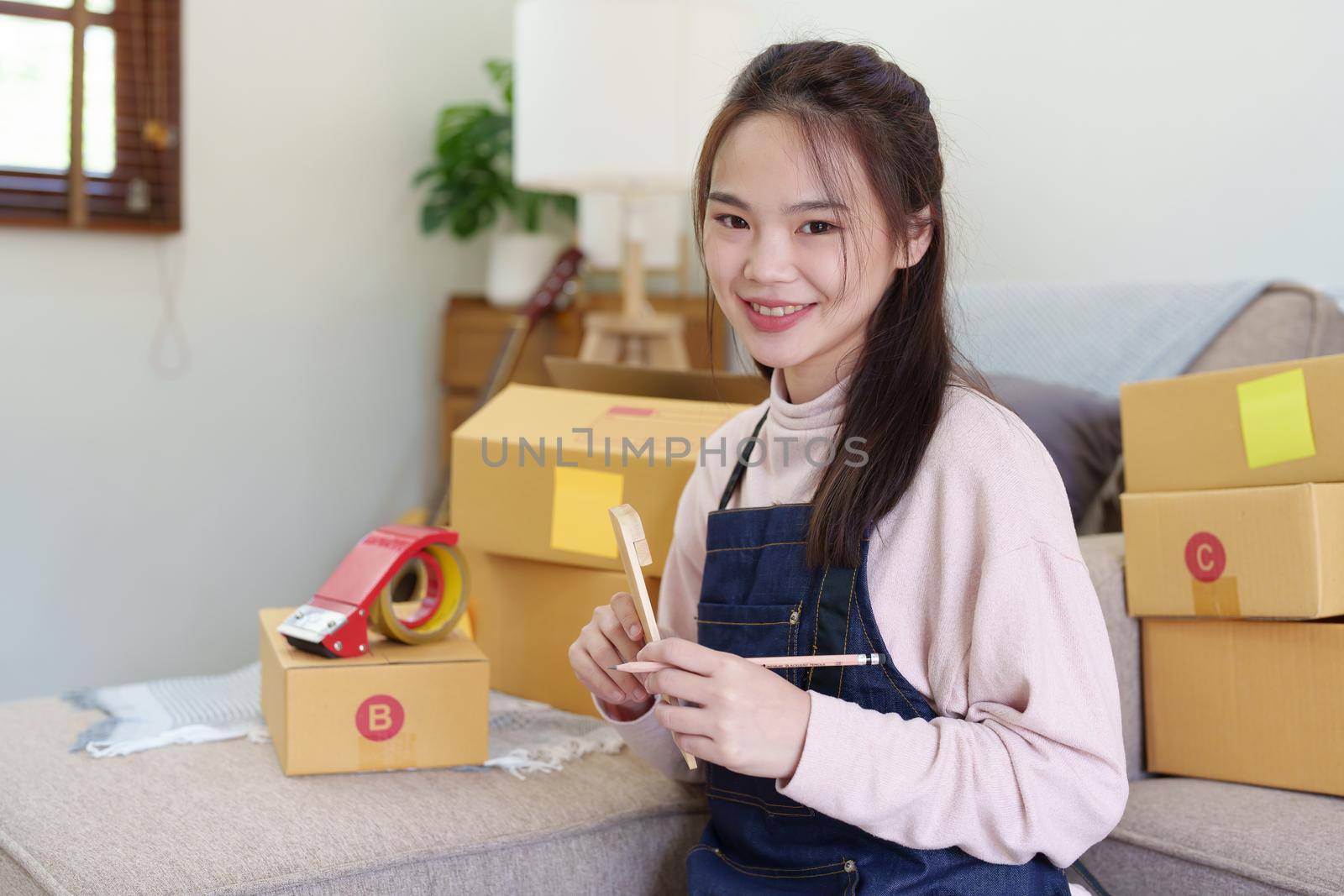 Portrait of Starting small businesses, Asian woman check online orders Selling products working with boxs freelance work at home office, sme business concepts