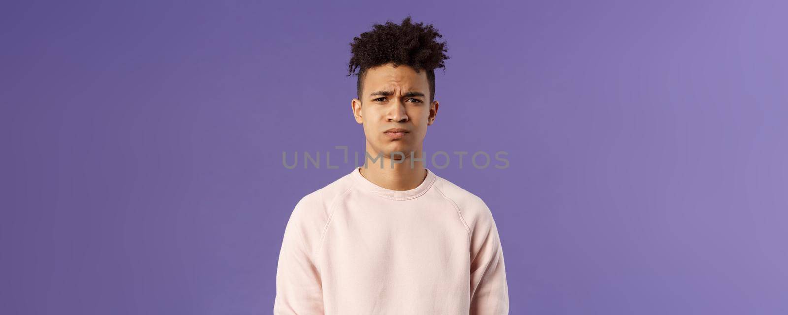 Close-up portrait of skeptical and gloomy, disappointed hispanic young man frowning upset, feel uneasy about bad idea, grimacing with disapproval, standing unhappy purple background by Benzoix