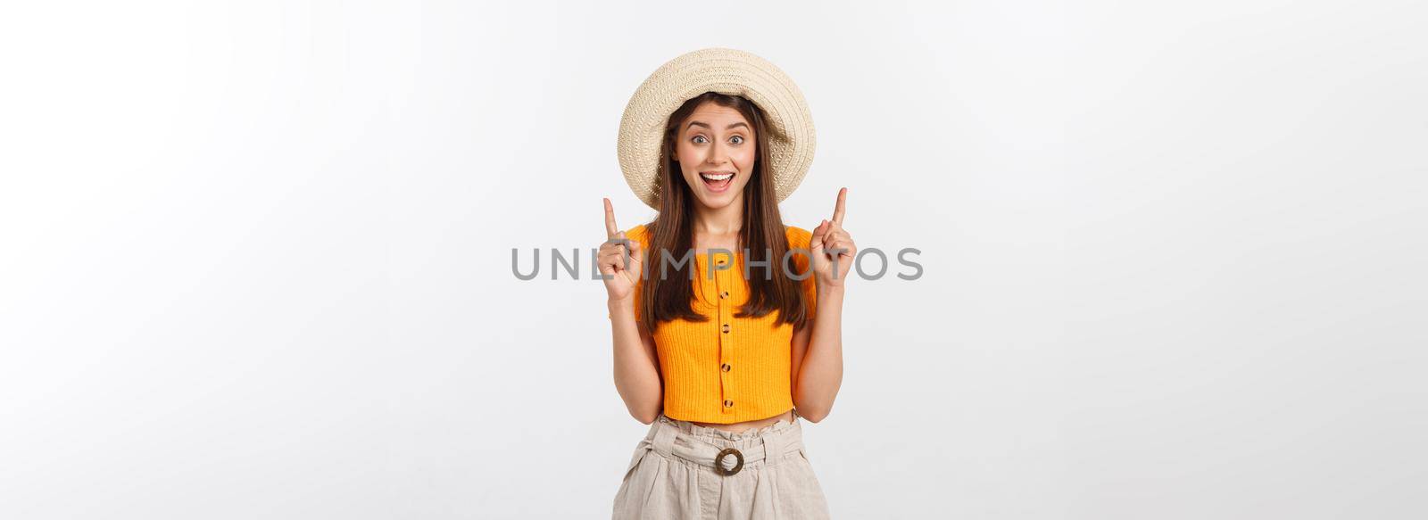 Teenager girl on summer vacation surprised and pointing finger on copy space over isolated white background. by Benzoix