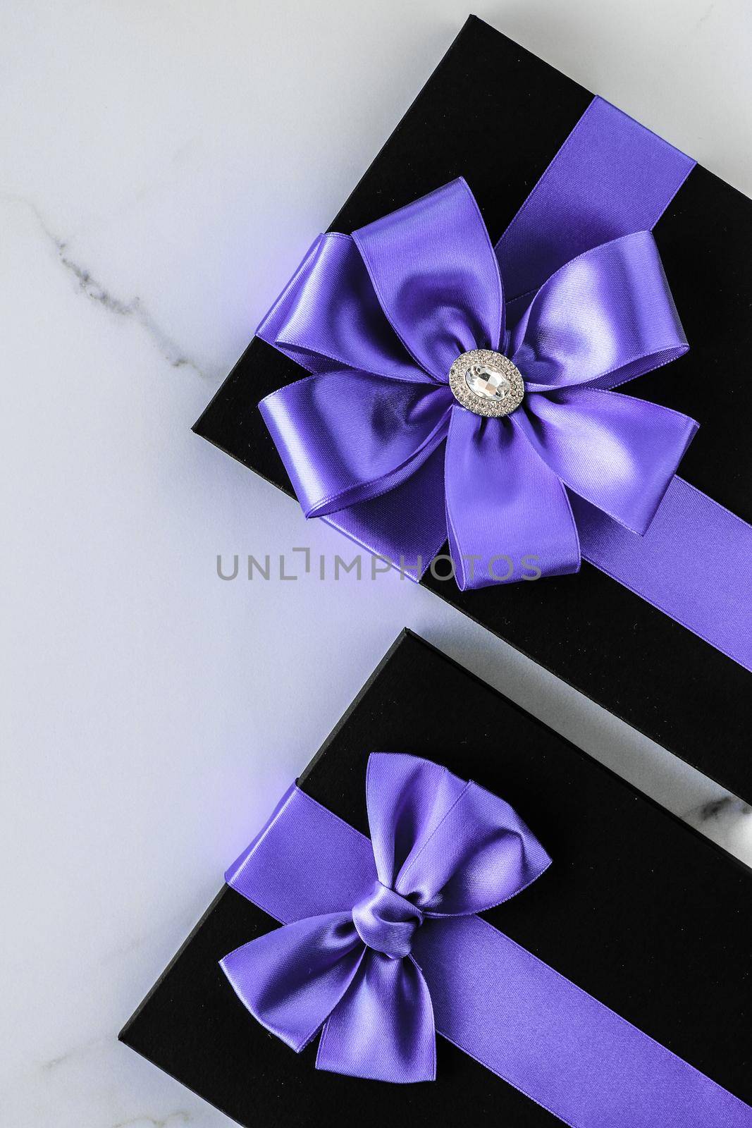 Luxury holiday gifts with lavender silk ribbon and bow on marble background by Anneleven