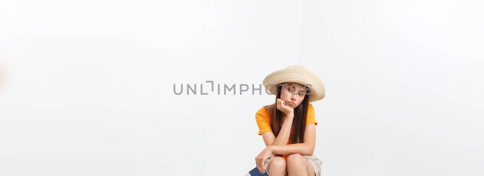 Lifestyle and travel Concept: Young beautiful caucasian woman is sitting on suitecase and waiting for her flight.Isolated over white background by Benzoix