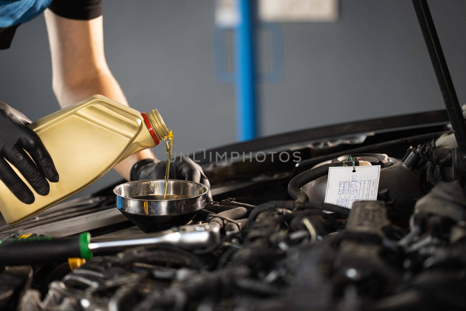 Close up of pouring fresh new motor oil into car's engine. New engine oil is poured into the engine. replacement of technical fluids of the car.