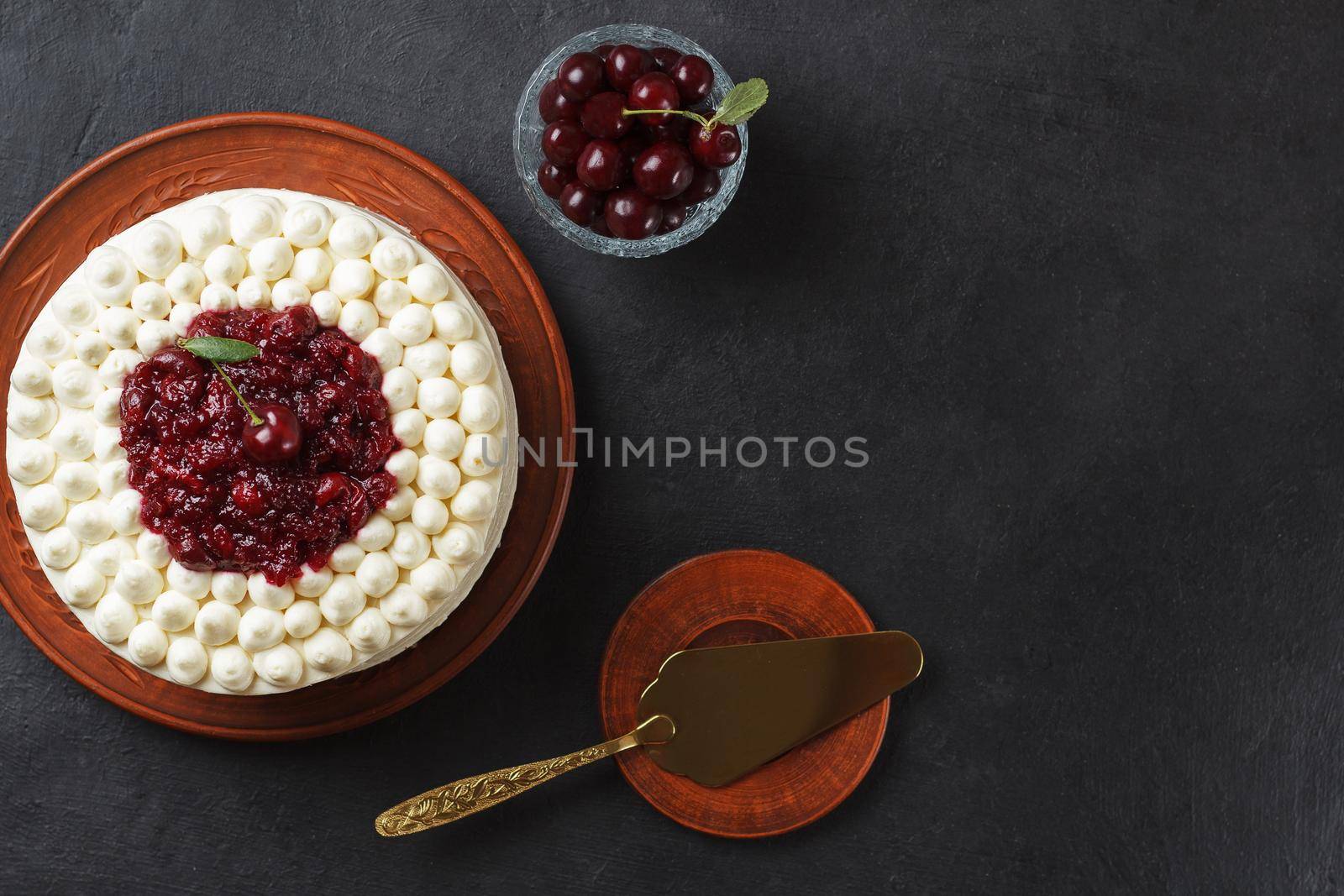 Biscuit cake, cherry souffl with cream cheese and cherry confiture on a black background. copy space